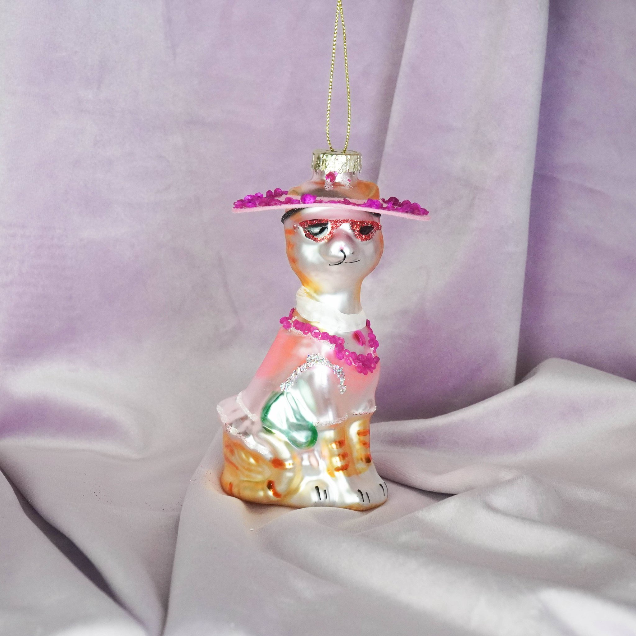 Diva-Katze Anhänger in Weiss-Rosa sitzt auf hellem Samtstoff