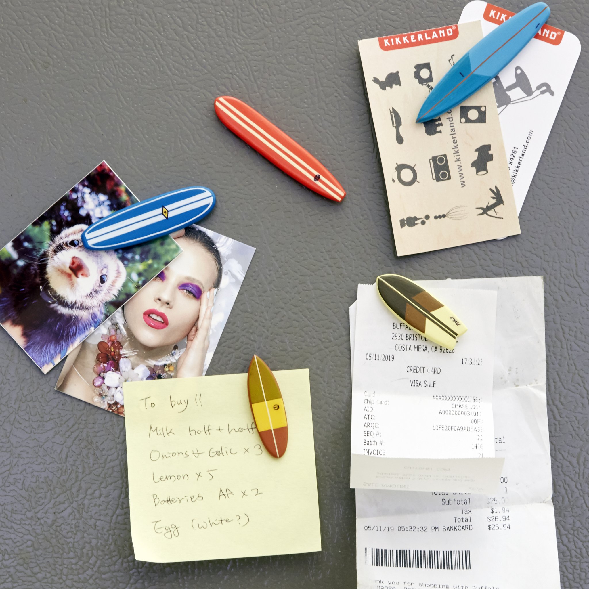 Surfbrett-Magnete halten Fotos, Notizen und Quittungen am Kühlschrank