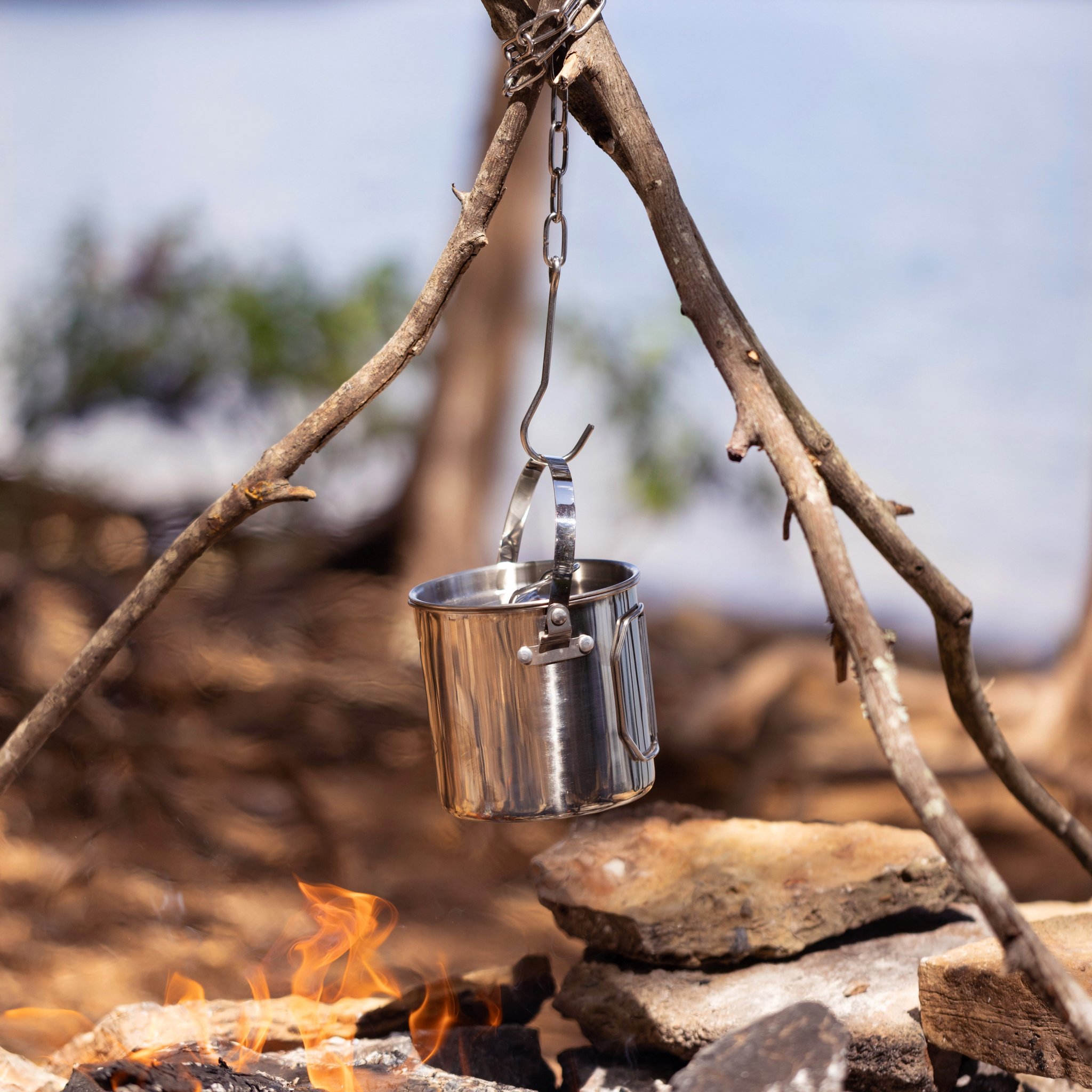 Campfire Cooking Pot hanging lower on the tripod, right above the blazing flames between stones
