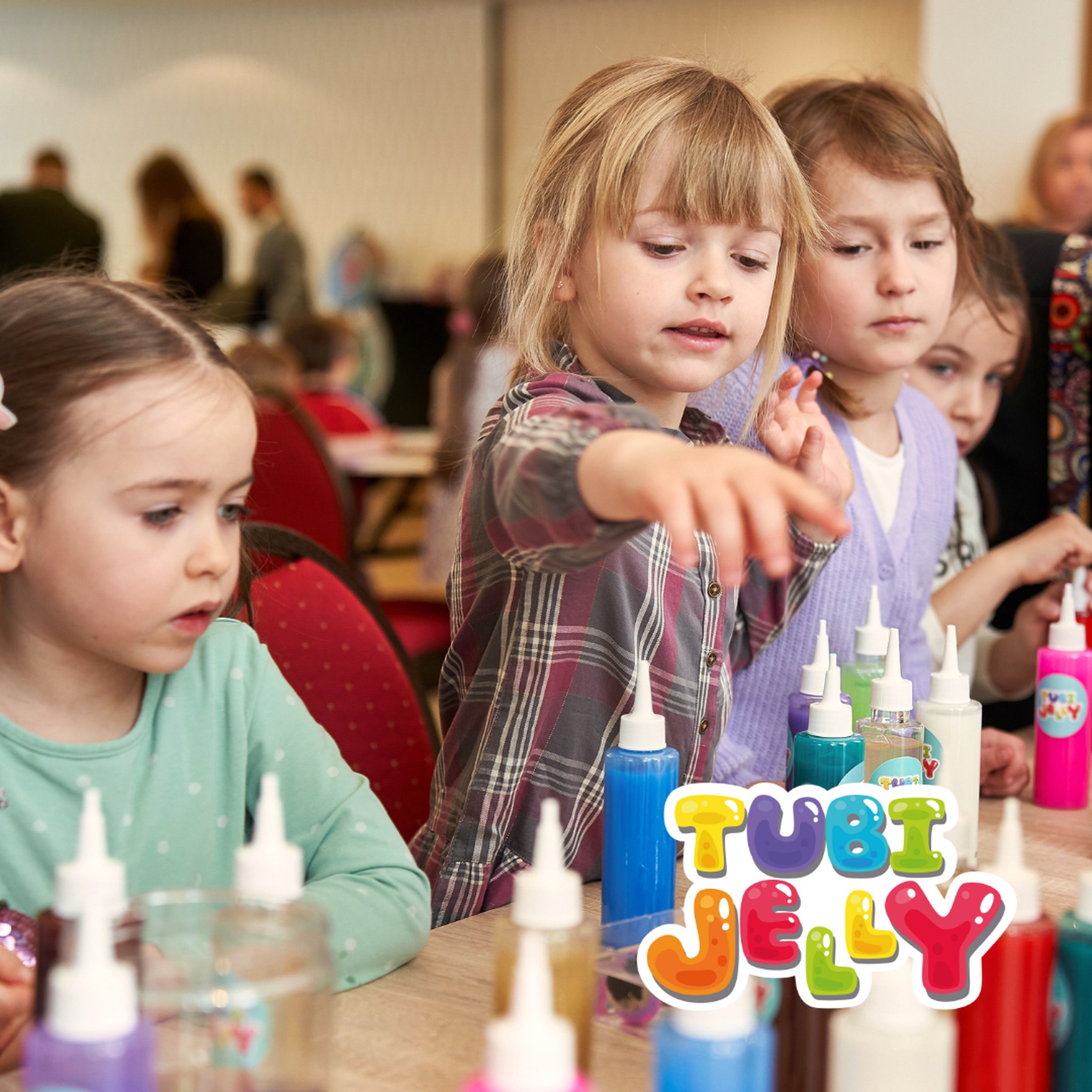 Mädchen gestaltet beim Basteln mit Tubi Jelly eine Gel-Figur, im Vordergrund die Gel-Flaschen