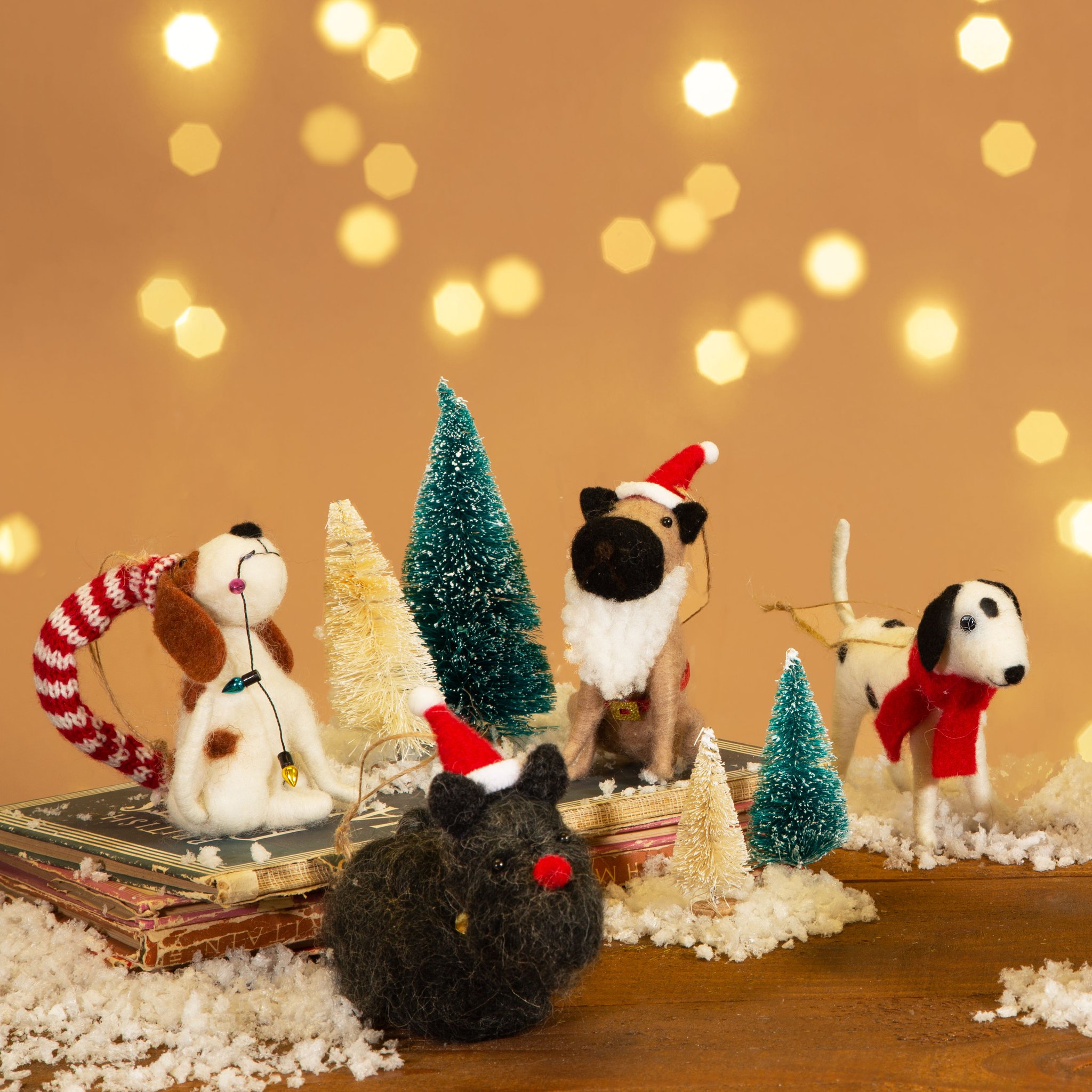 Chien en feutre dans un décor enneigé avec petits sapins et autres figurines en feutre