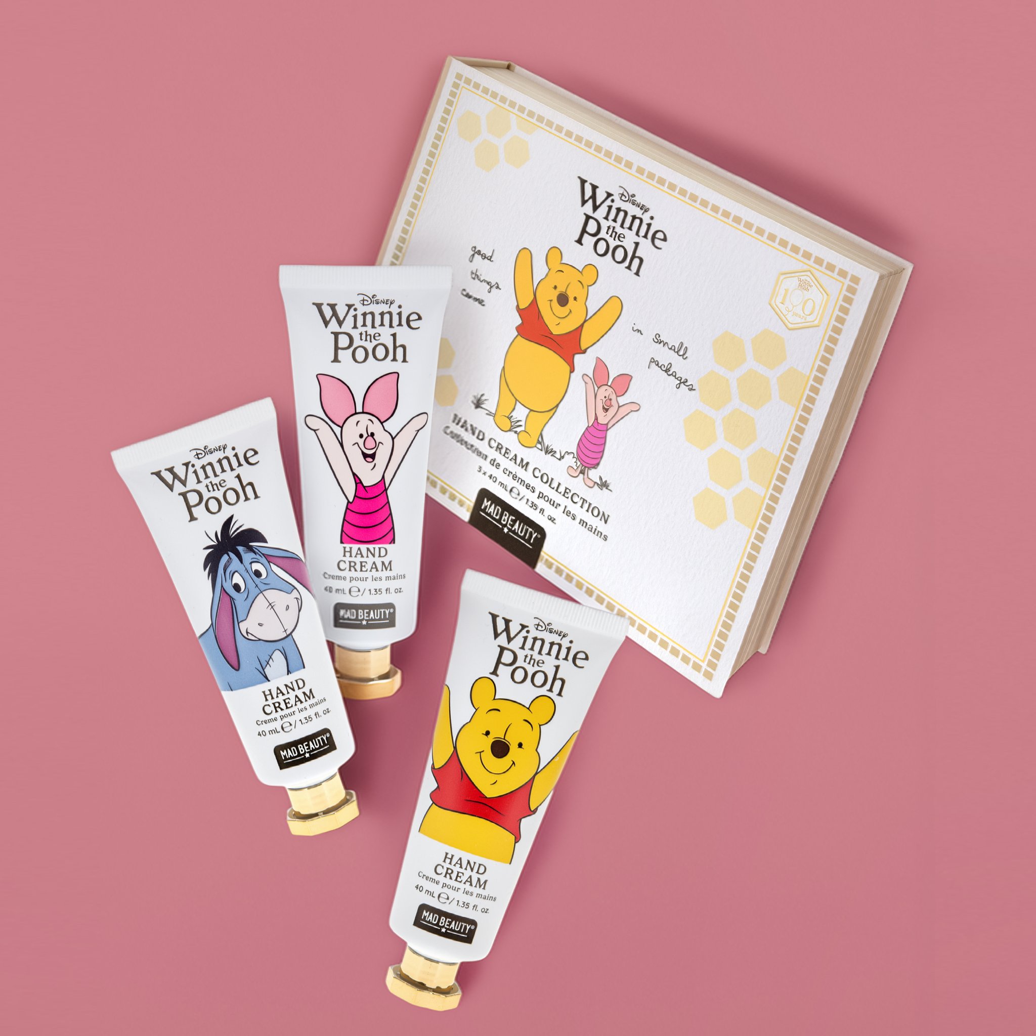 Drei Winnie Puuh Handcremes mit Puuh, I-Aah und Ferkel vor der Buchverpackung zum Jubiläum