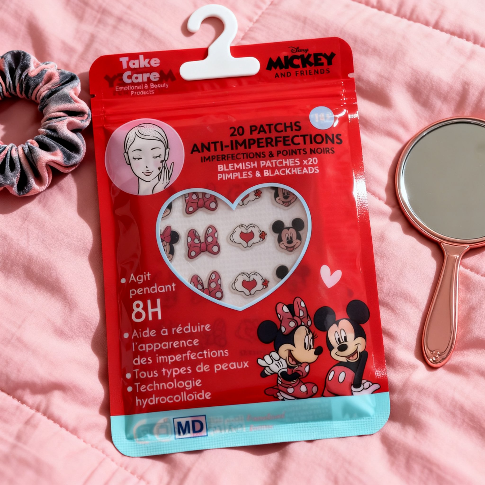 Minnie Mouse blemish patches with hanging hook on a pink bedspread with a scrunchie and hand mirror