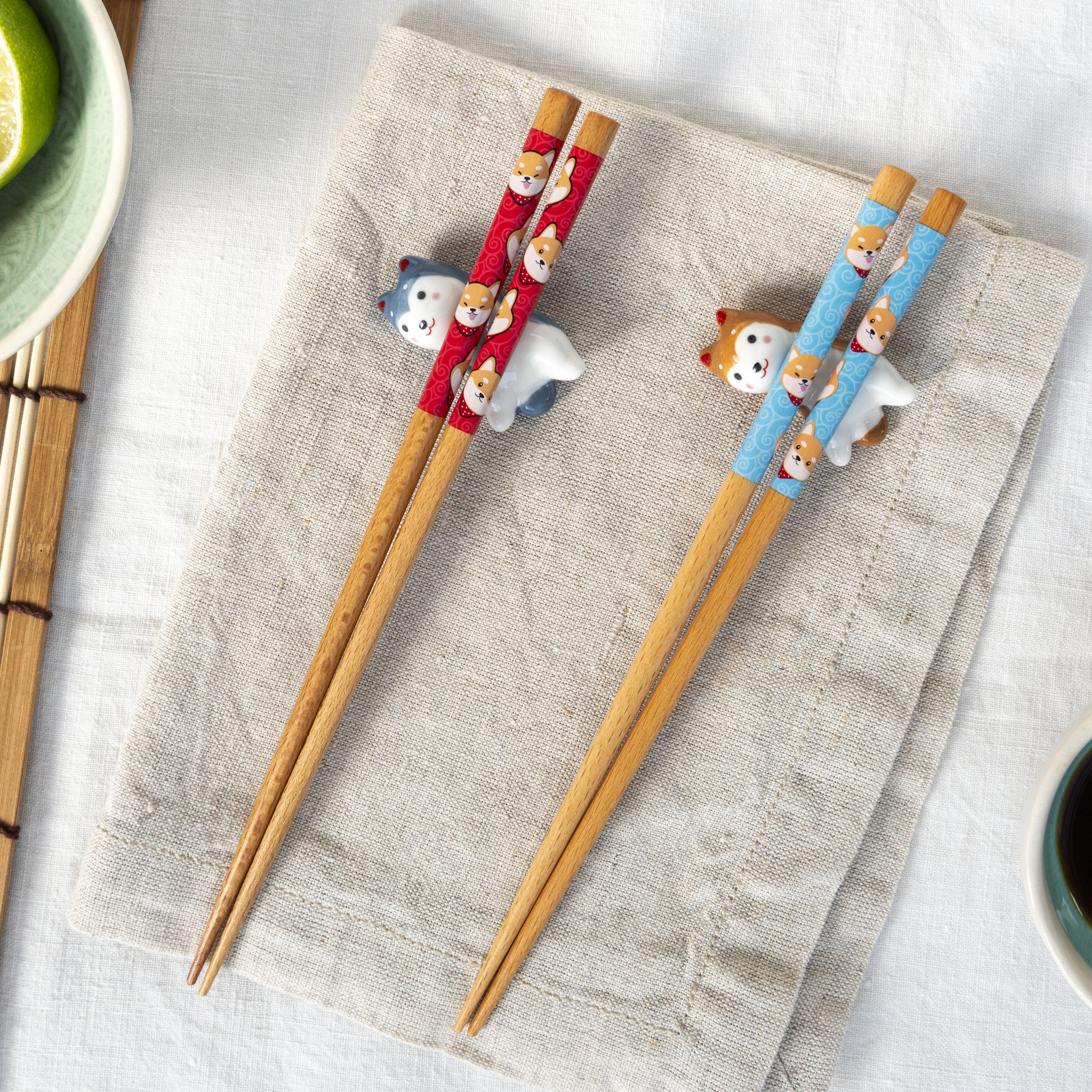 Set bacchette cane: bacchette di bambù rosse e blu su cani in ceramica, su lino