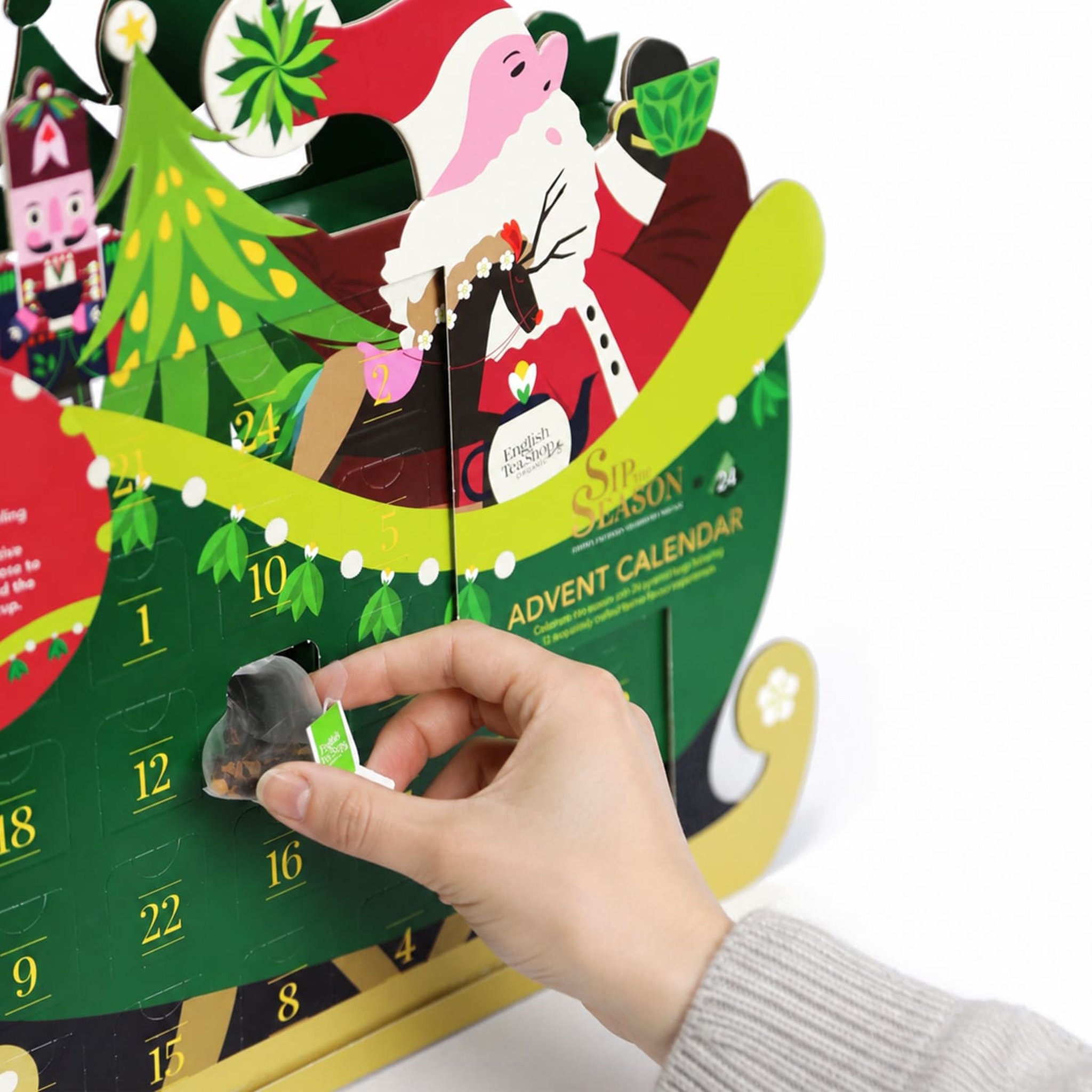 Une main ouvre une case du calendrier traîneau et en sort un sachet pyramide
