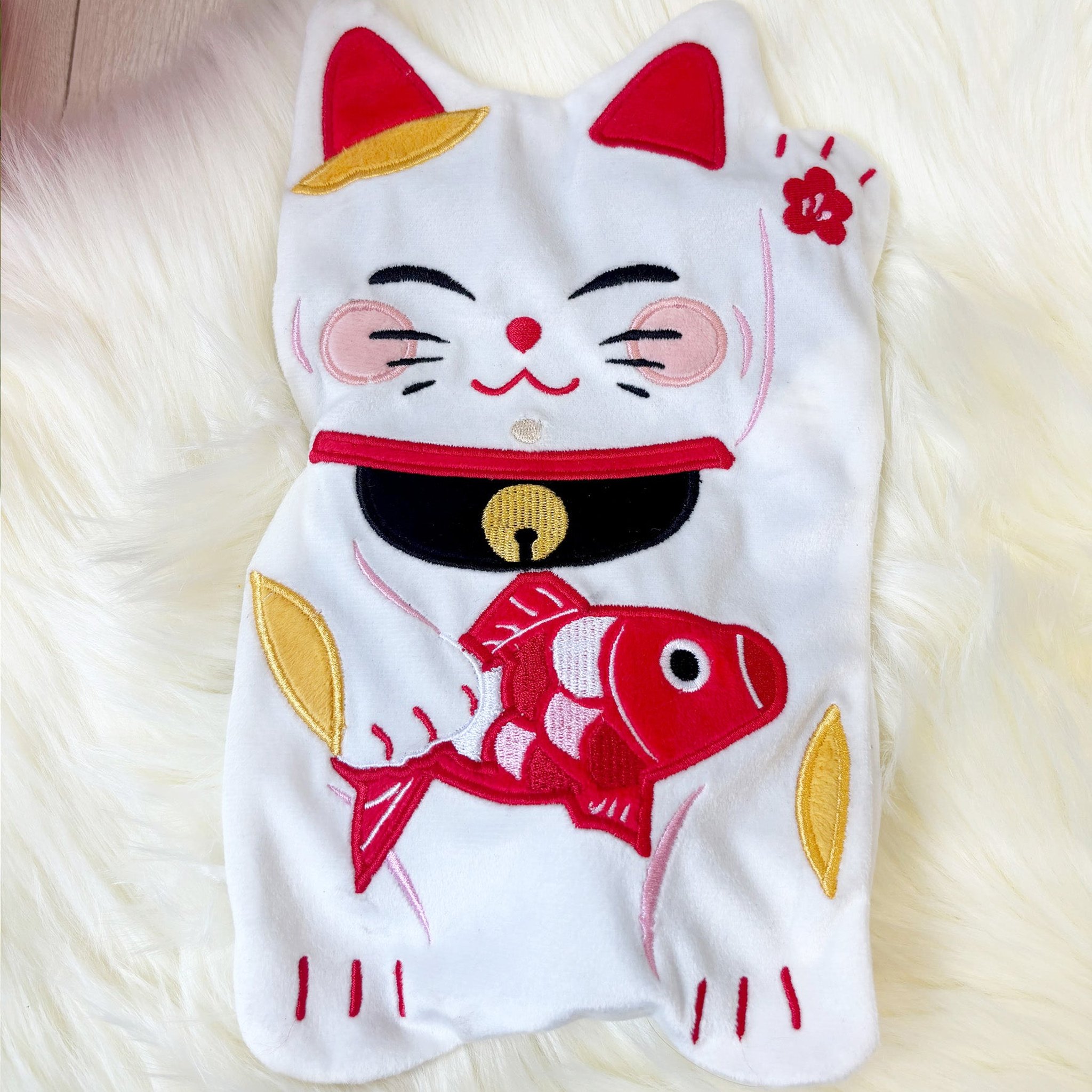 Close-up of the lucky cat with bell, collar and koi