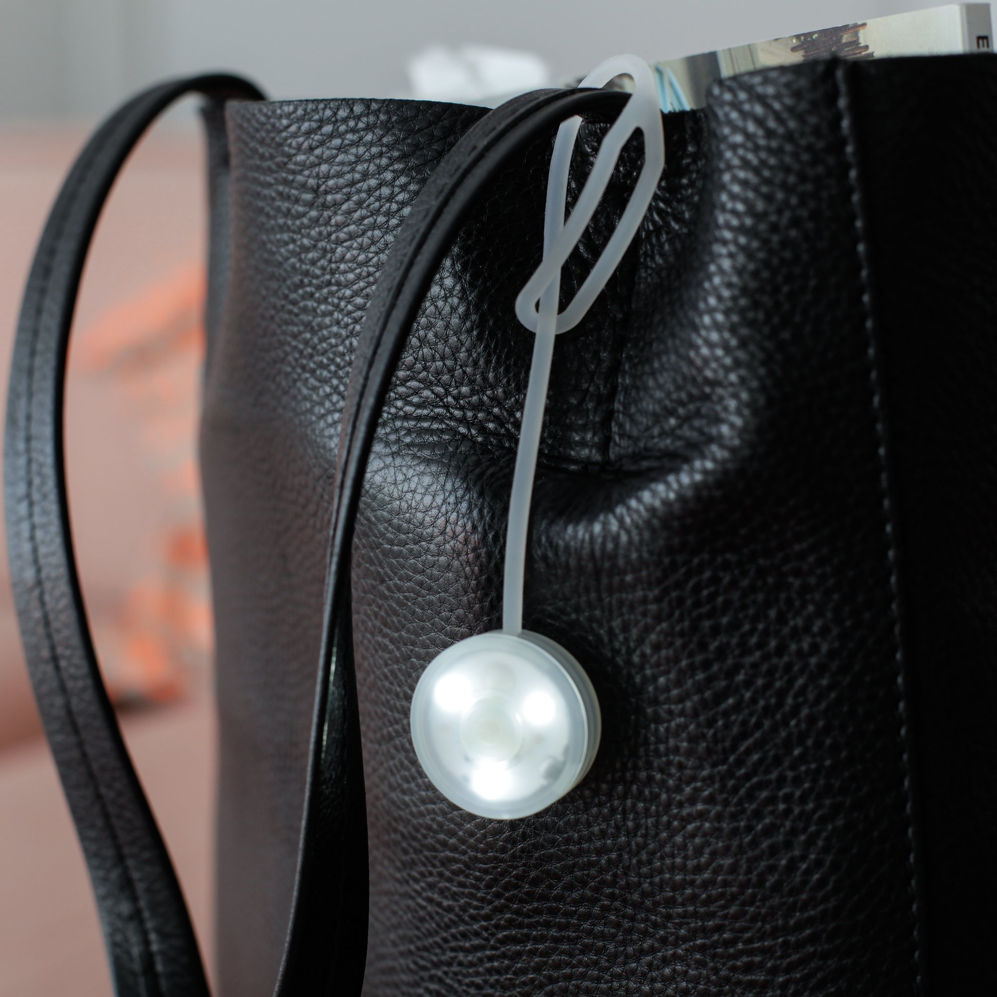 Leuchtende Handtaschen-Lampe an der Silikonschlaufe am Taschenrand