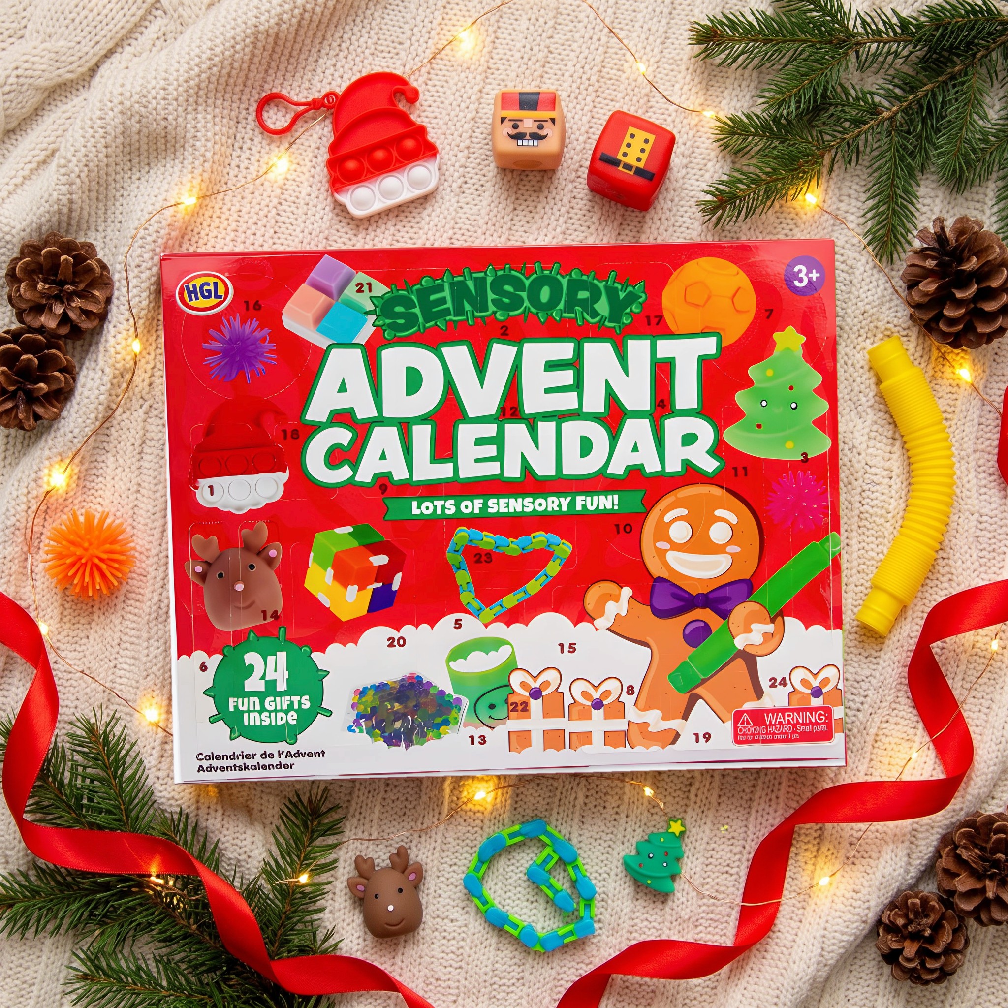 Calendrier de l'Avent fidget sur une couverture tricotée avec branches de sapin, guirlande lumineuse et jouets sensoriels comme pop-it, cubes squishy et pop tube