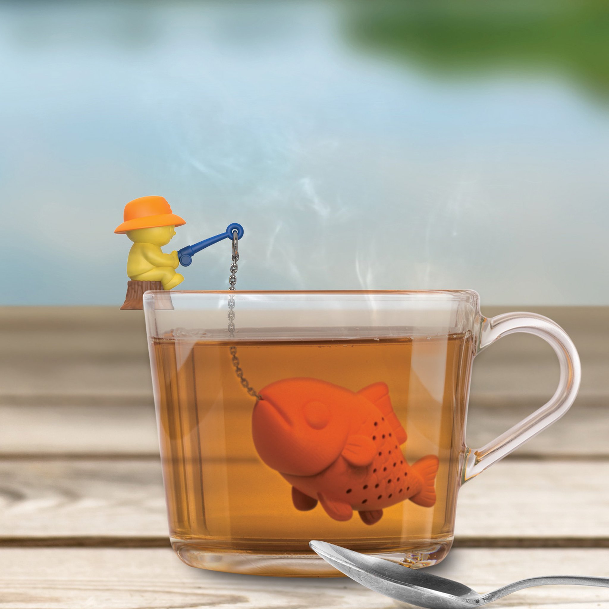 Big Fish Tee-Ei auf einem Holztisch am Wasser, Tee dampft