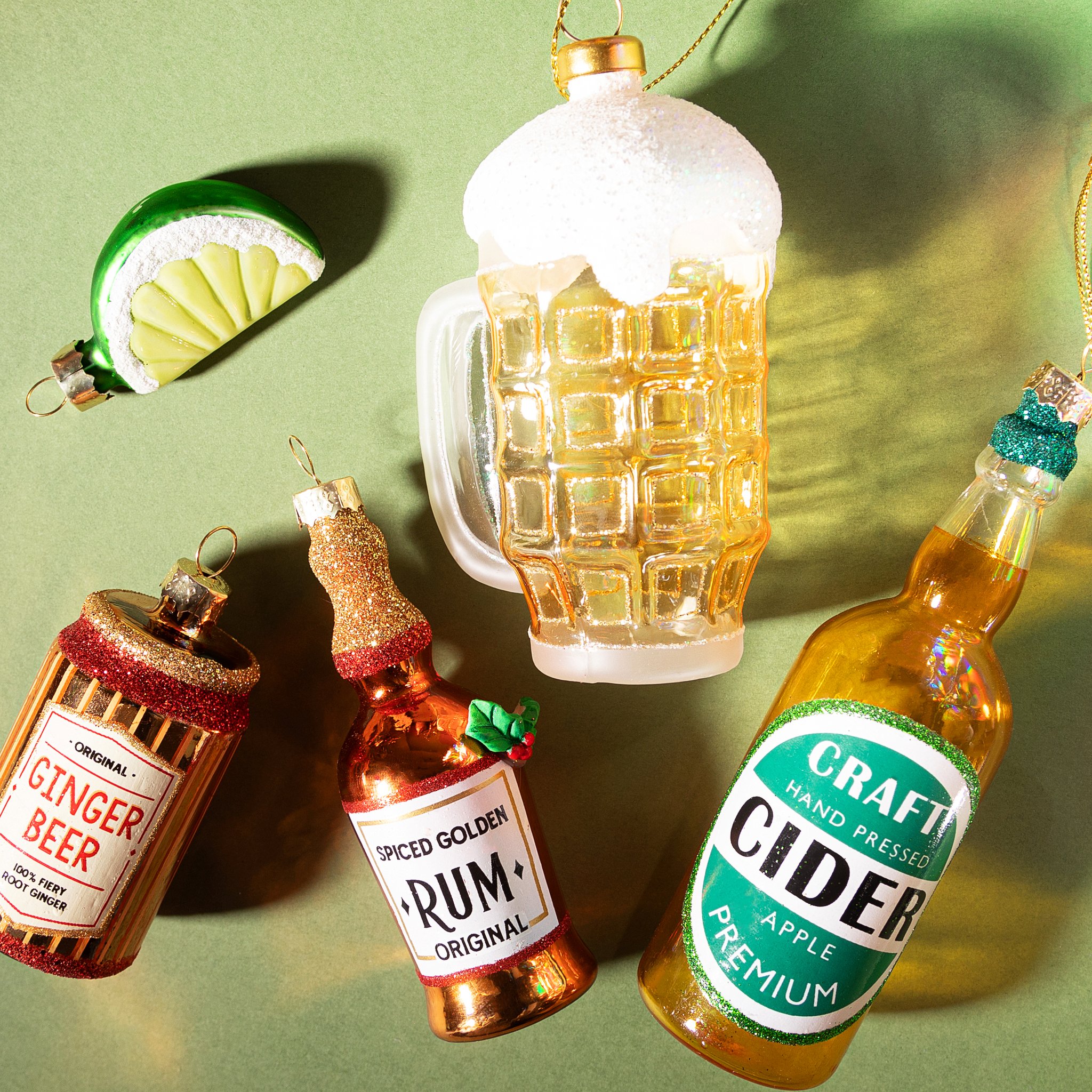 Bierkrug Weihnachtsbaumschmuck von Sass & Belle mit Ginger-Beer-, Rum- und Cider-Anhängern auf grünem Grund
