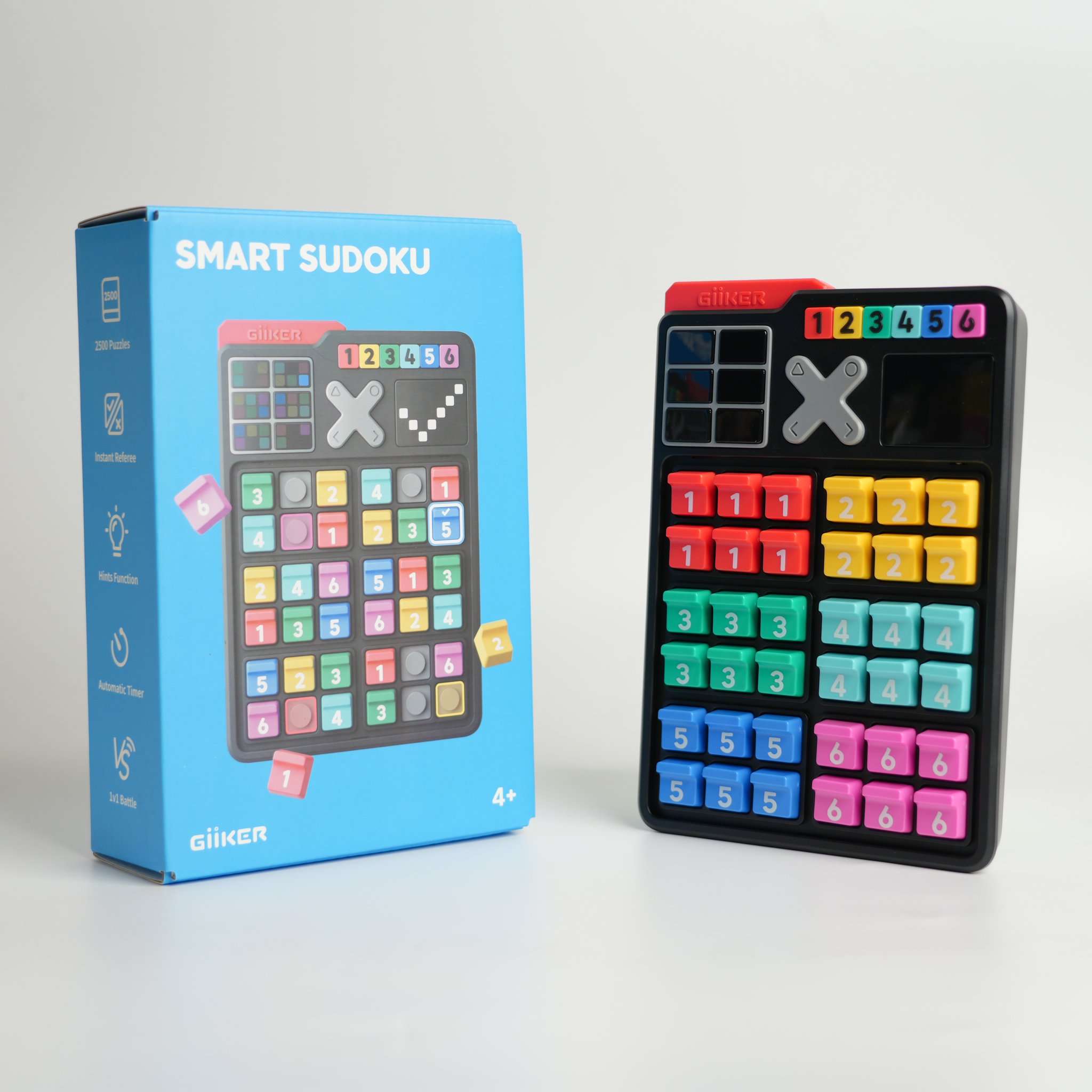 Console Smart Sudoku à côté de son emballage bleu, photo studio sur fond neutre.