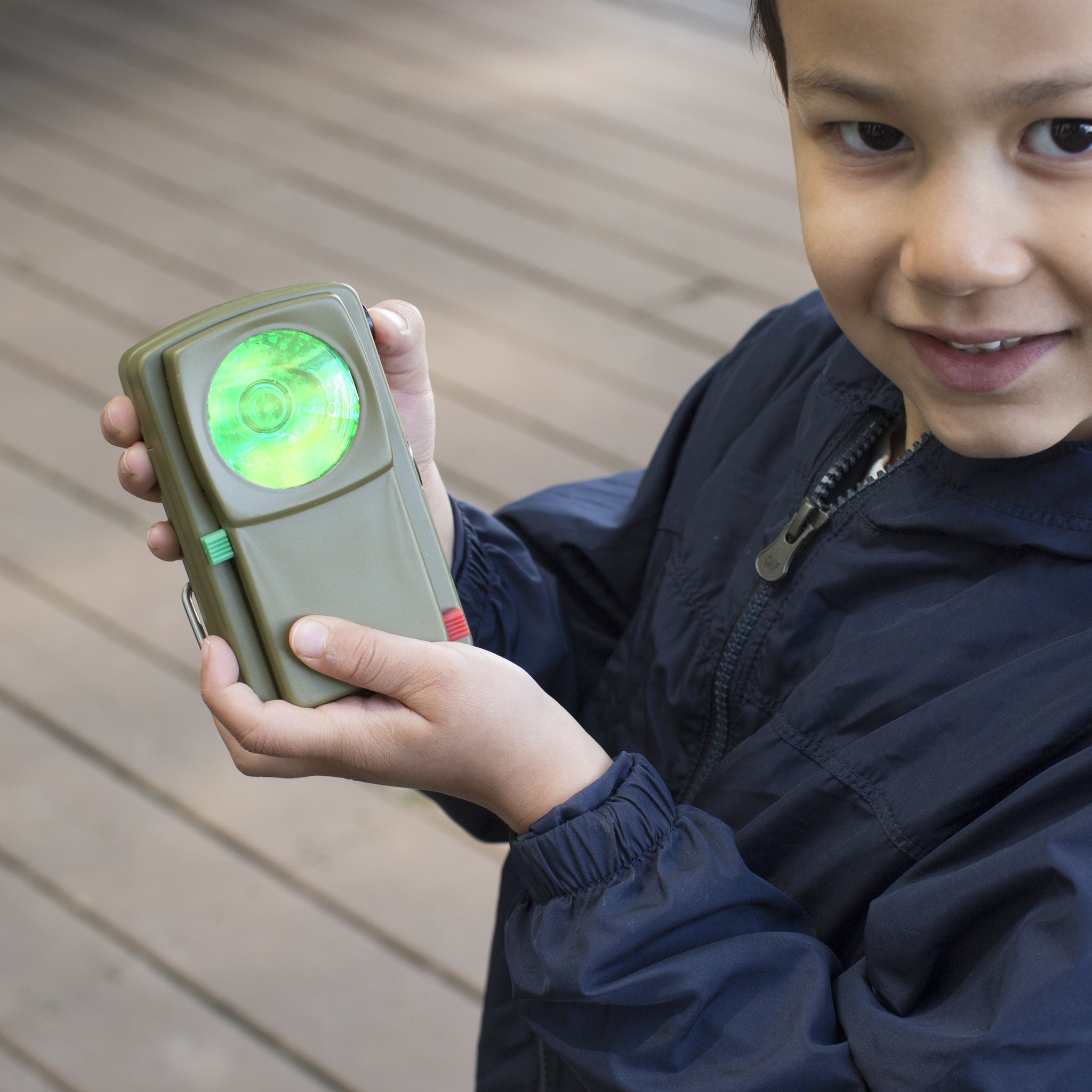 Boy holding the Morse code torch with green glowing lens