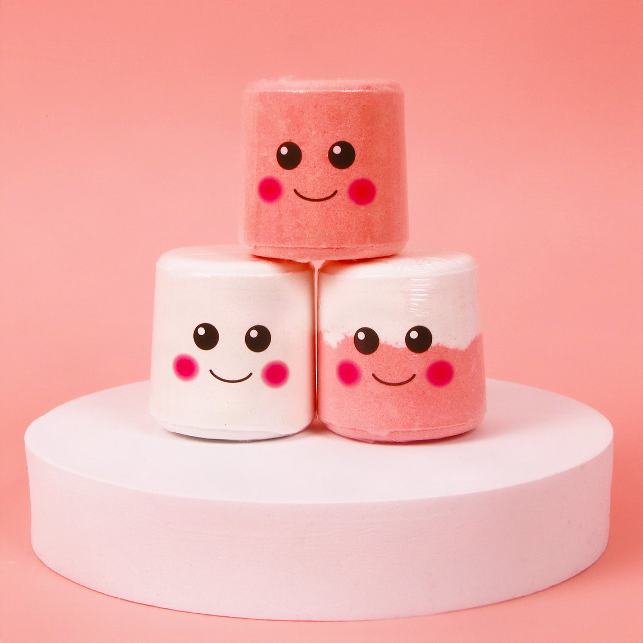 Three marshmallow bath bombs in white, white and pink, and pink stacked up