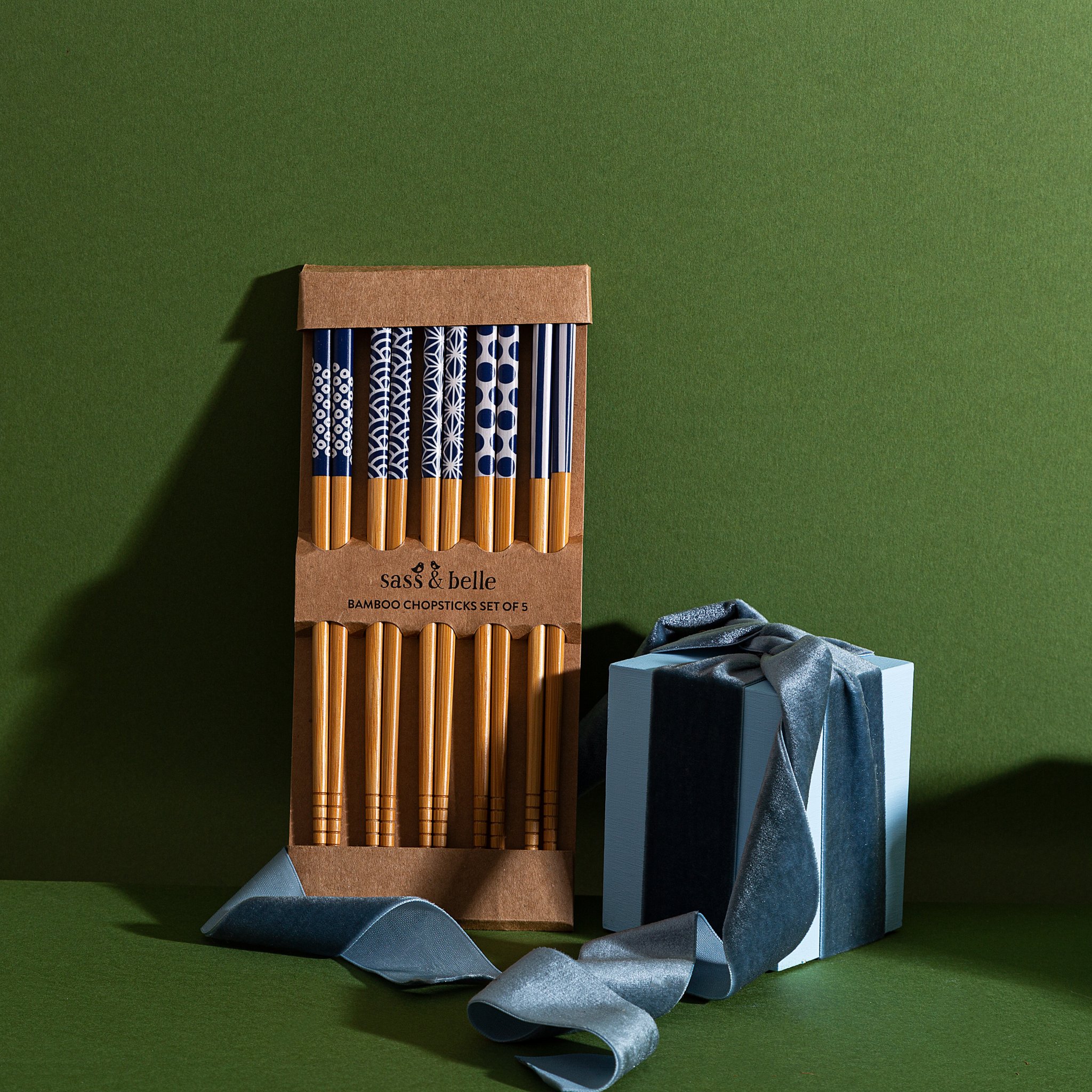 Japandi Essstäbchen-Set in der Verpackung auf grünem Grund mit blauem Band
