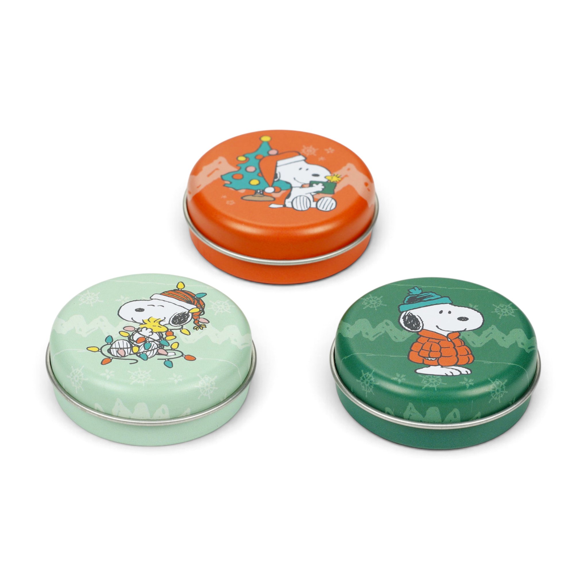 Drei Snoopy Weihnachts-Lippenbalsam-Dosen in Mint, Orange und Grün