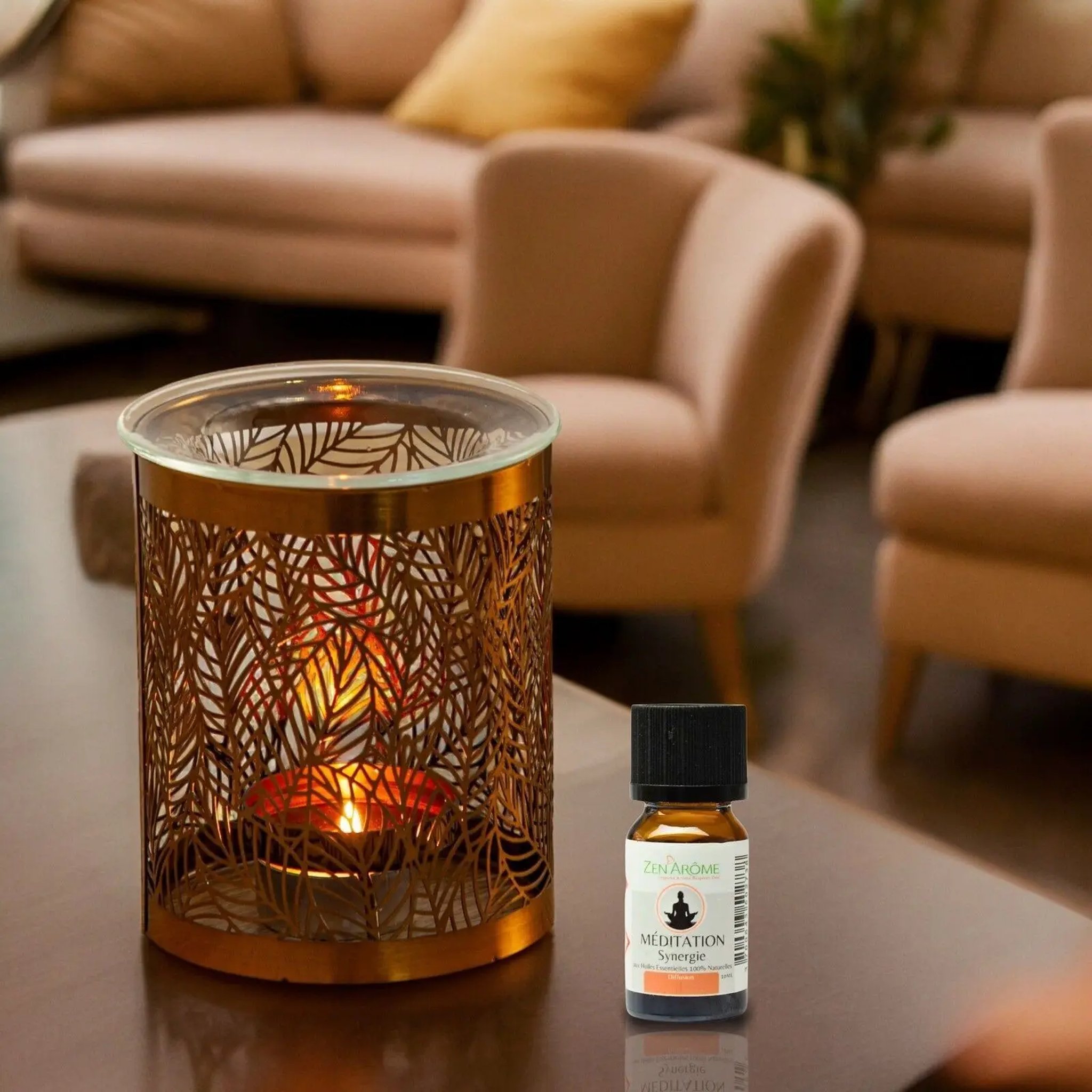 Glowing metal and glass oil burner in a living room with a small bottle of fragrance oil