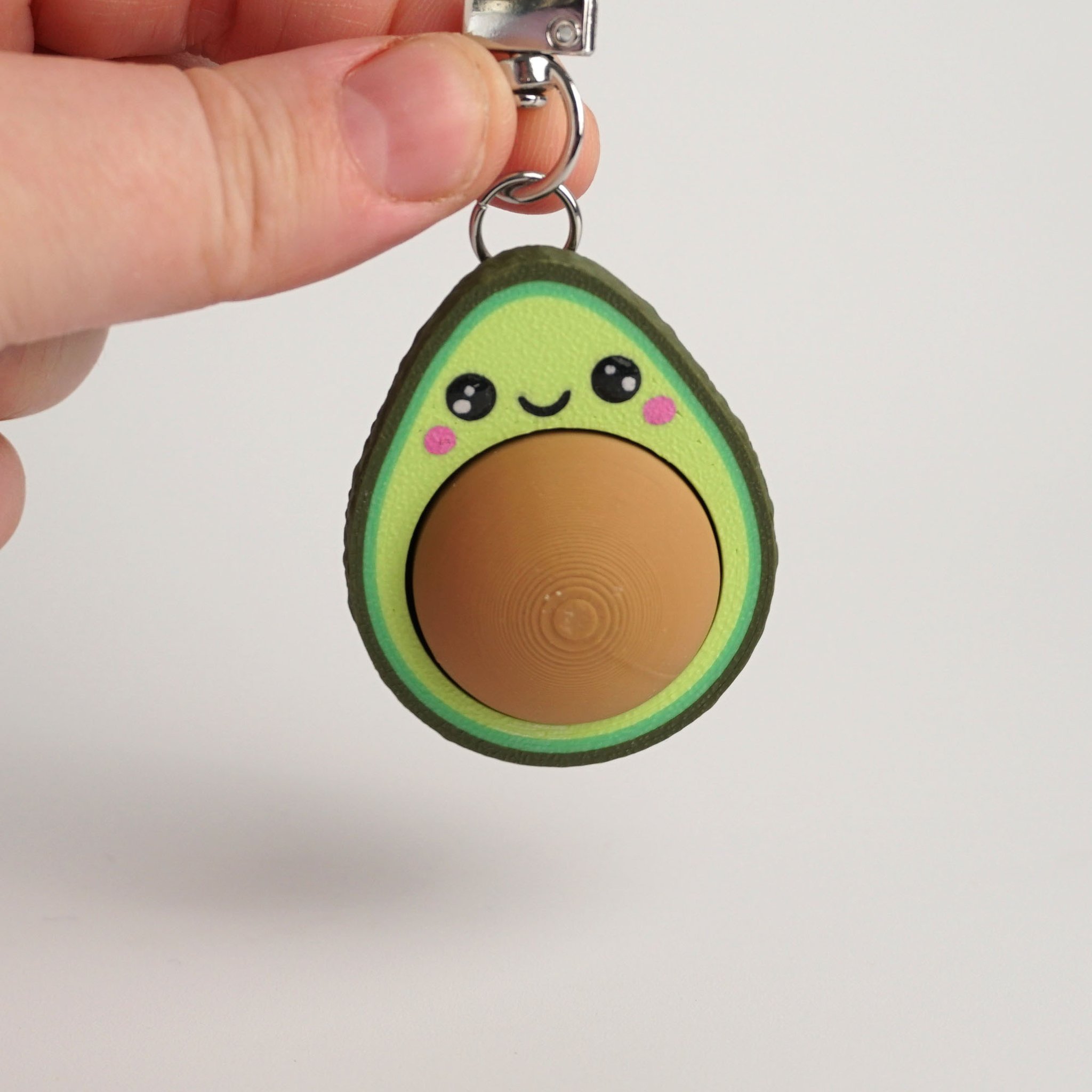 Tukitsu Avocado Clicker Schlüsselanhänger — Kawaii-Gesicht in der Hand