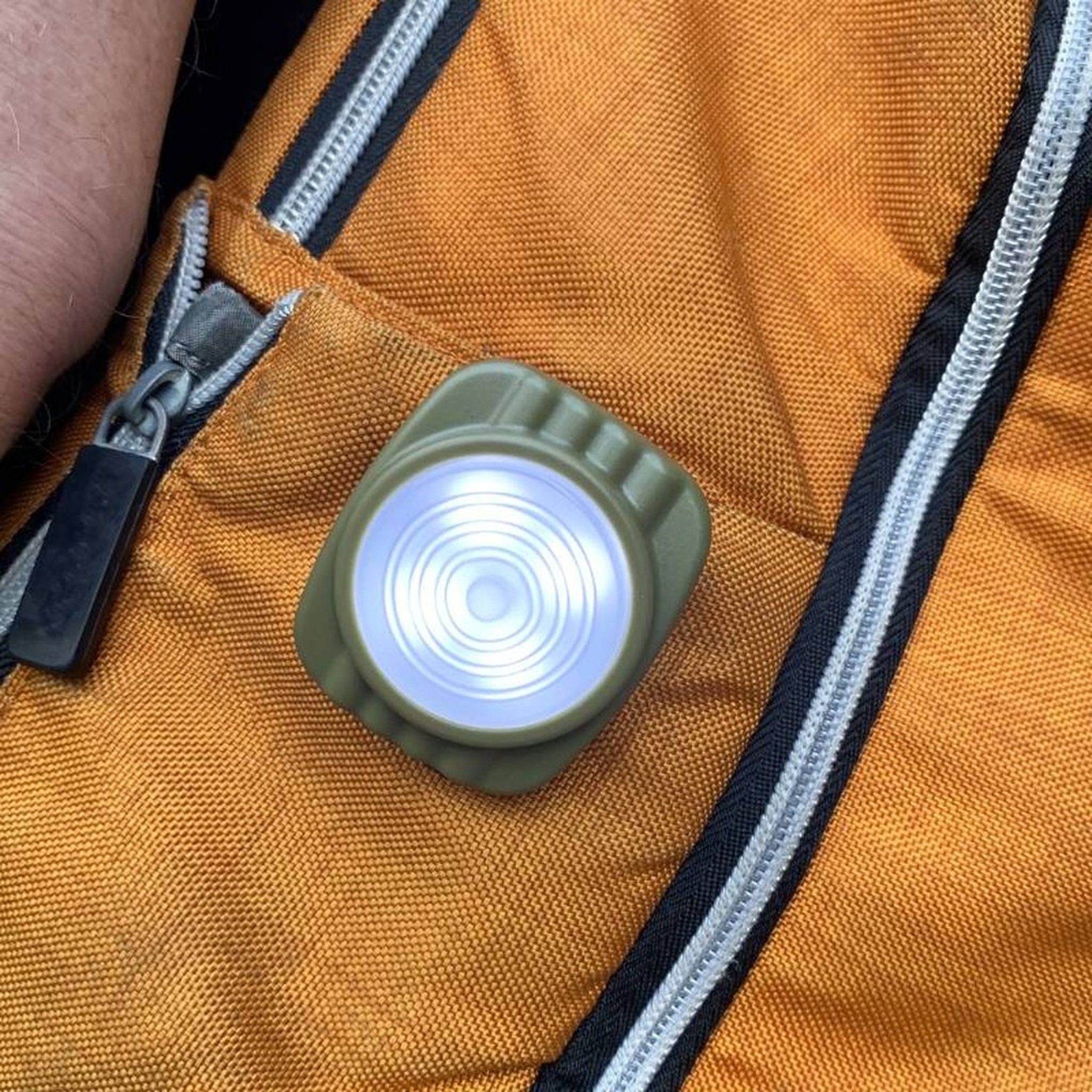 Clip-Lampe leuchtet an einer orangen Jacke
