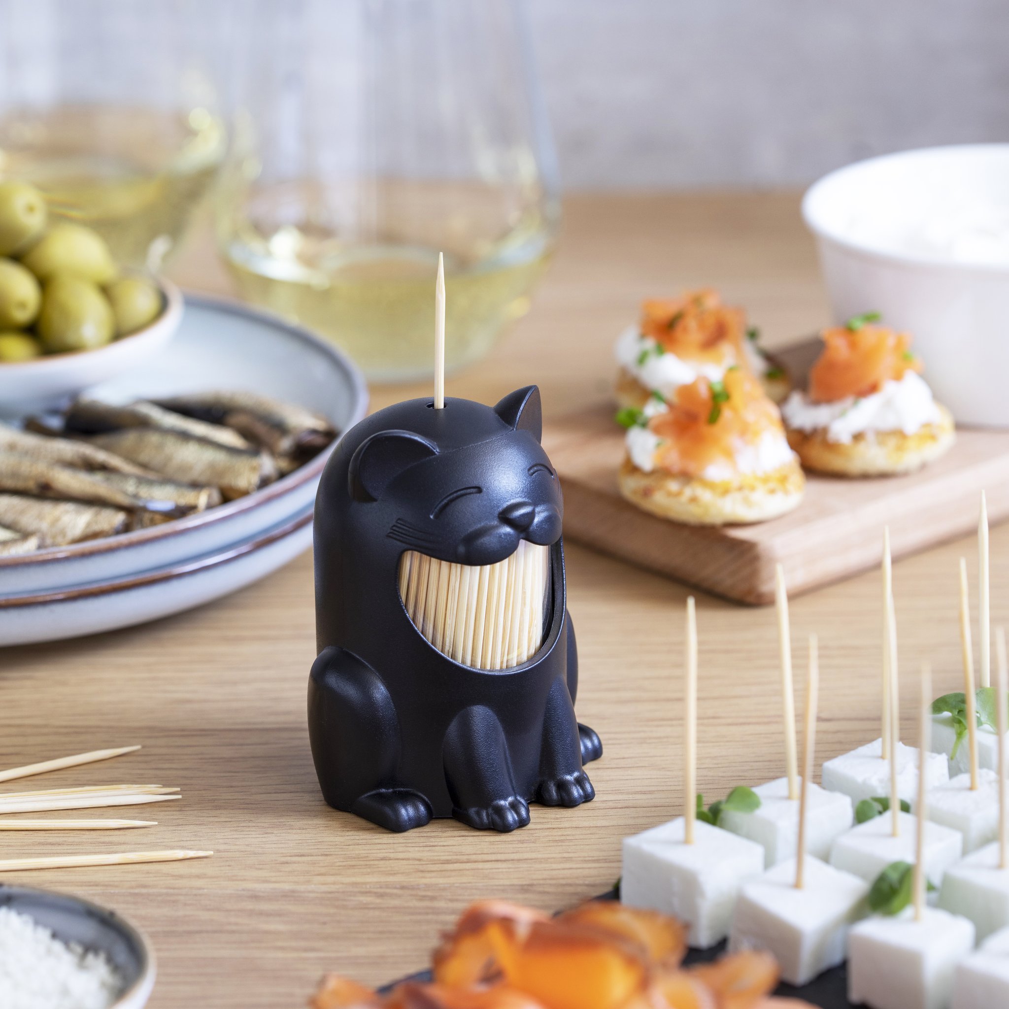 Pickitty Zahnstocherspender neben Oliven und Weisswein