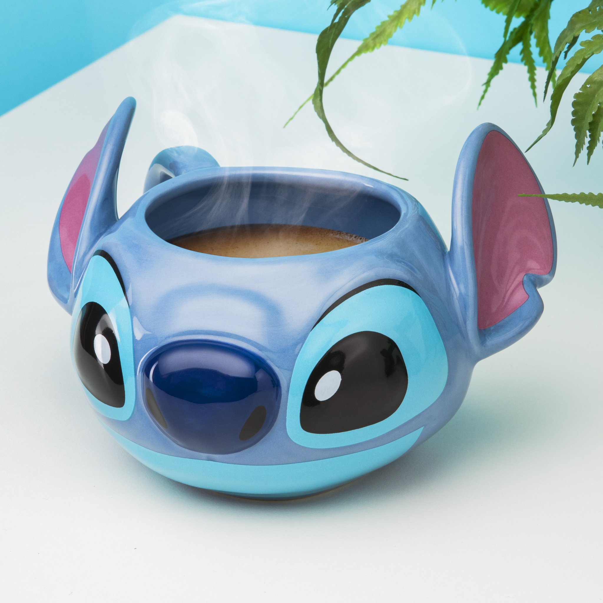 Stitch-Tasse von vorne, gefüllt mit einem dampfenden Getränk