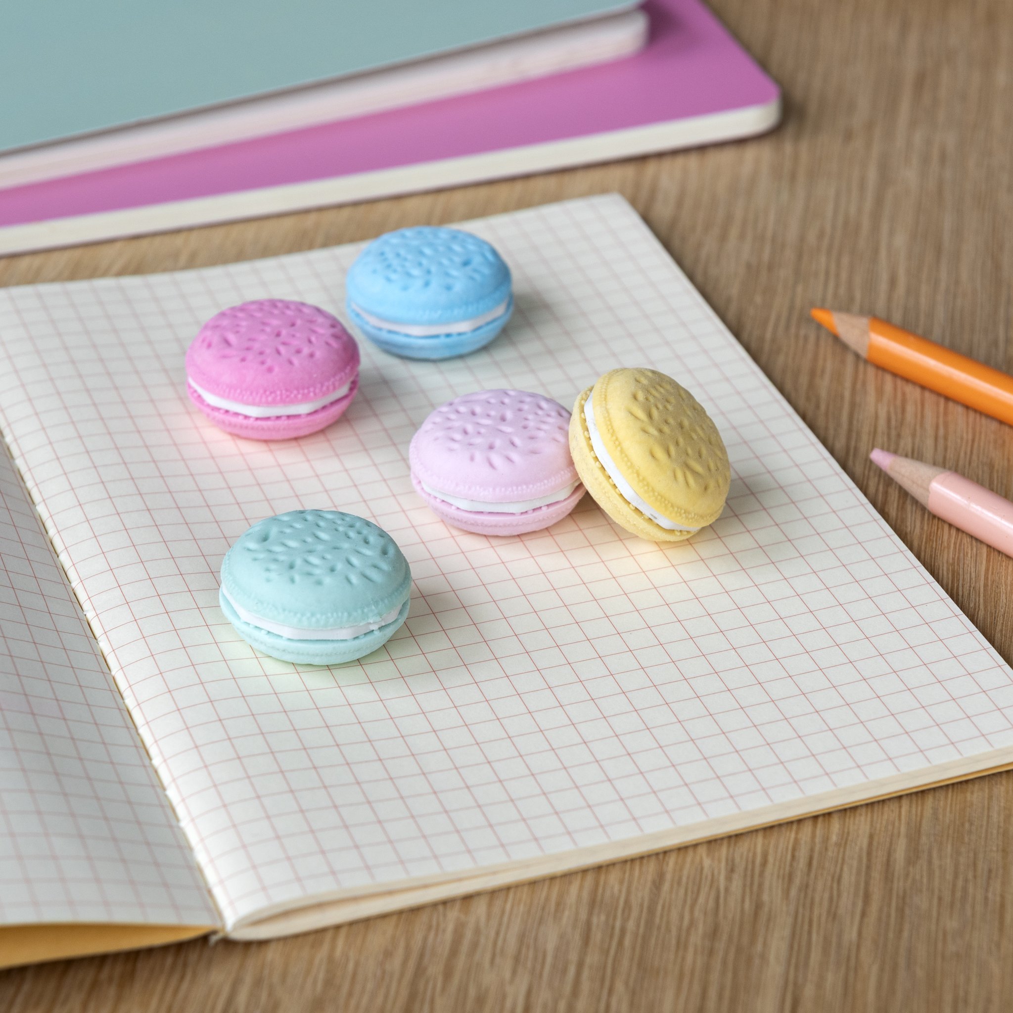 Gomme macaron su un quaderno a quadretti con matite colorate