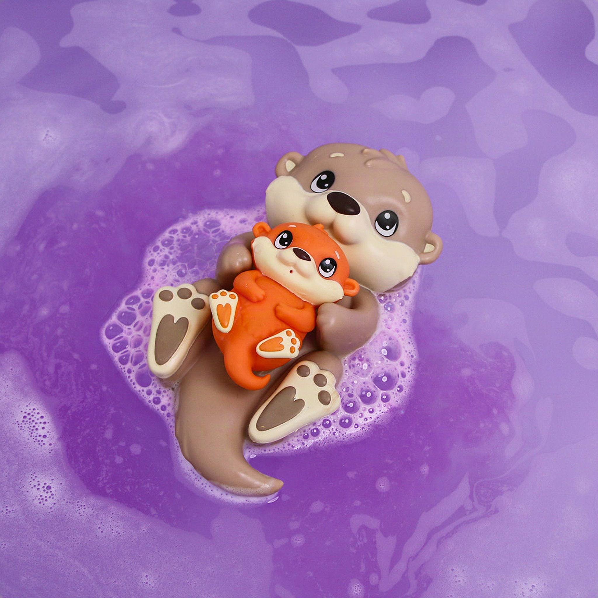 Mother otter with her baby seen from above in purple-coloured bath water
