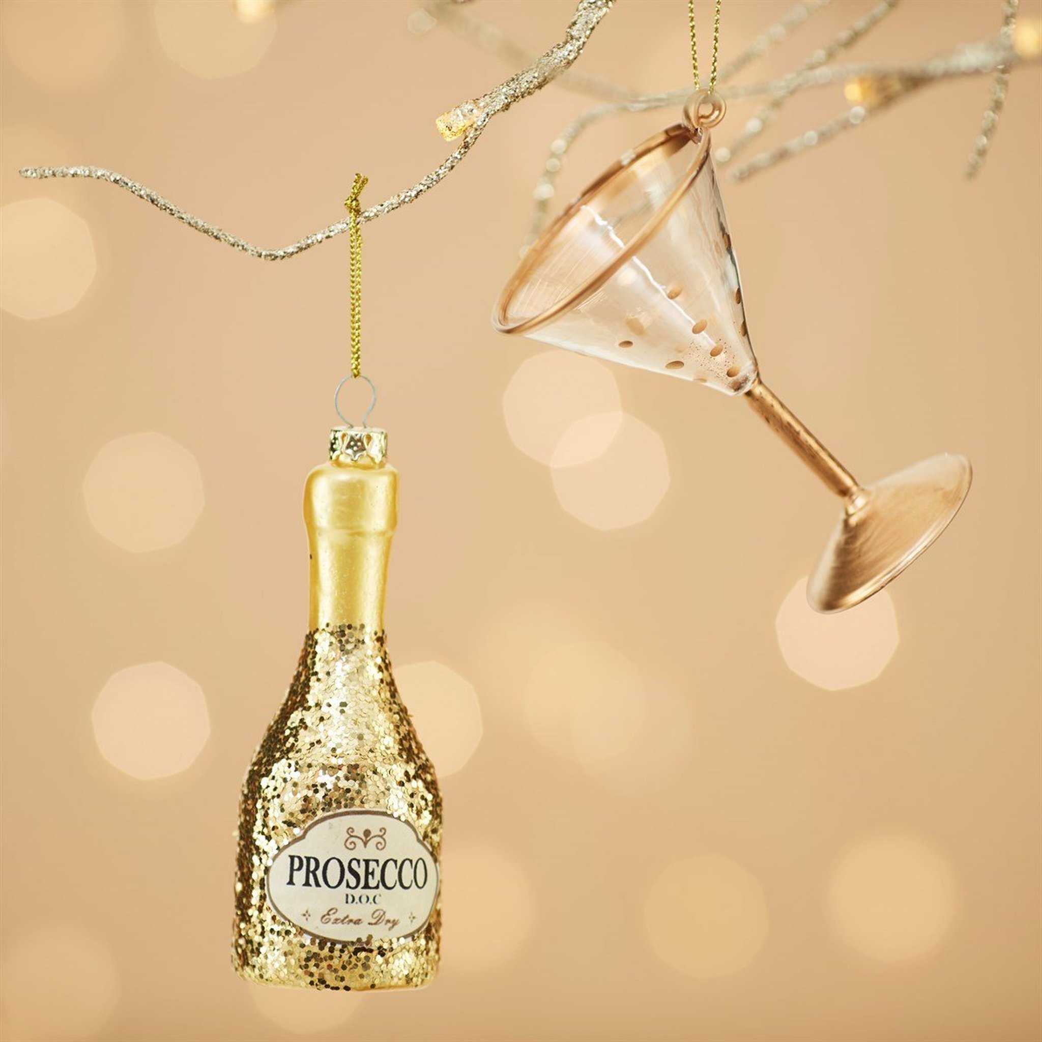Décoration de sapin bouteille de prosecco en gros plan avec ornement verre à cocktail