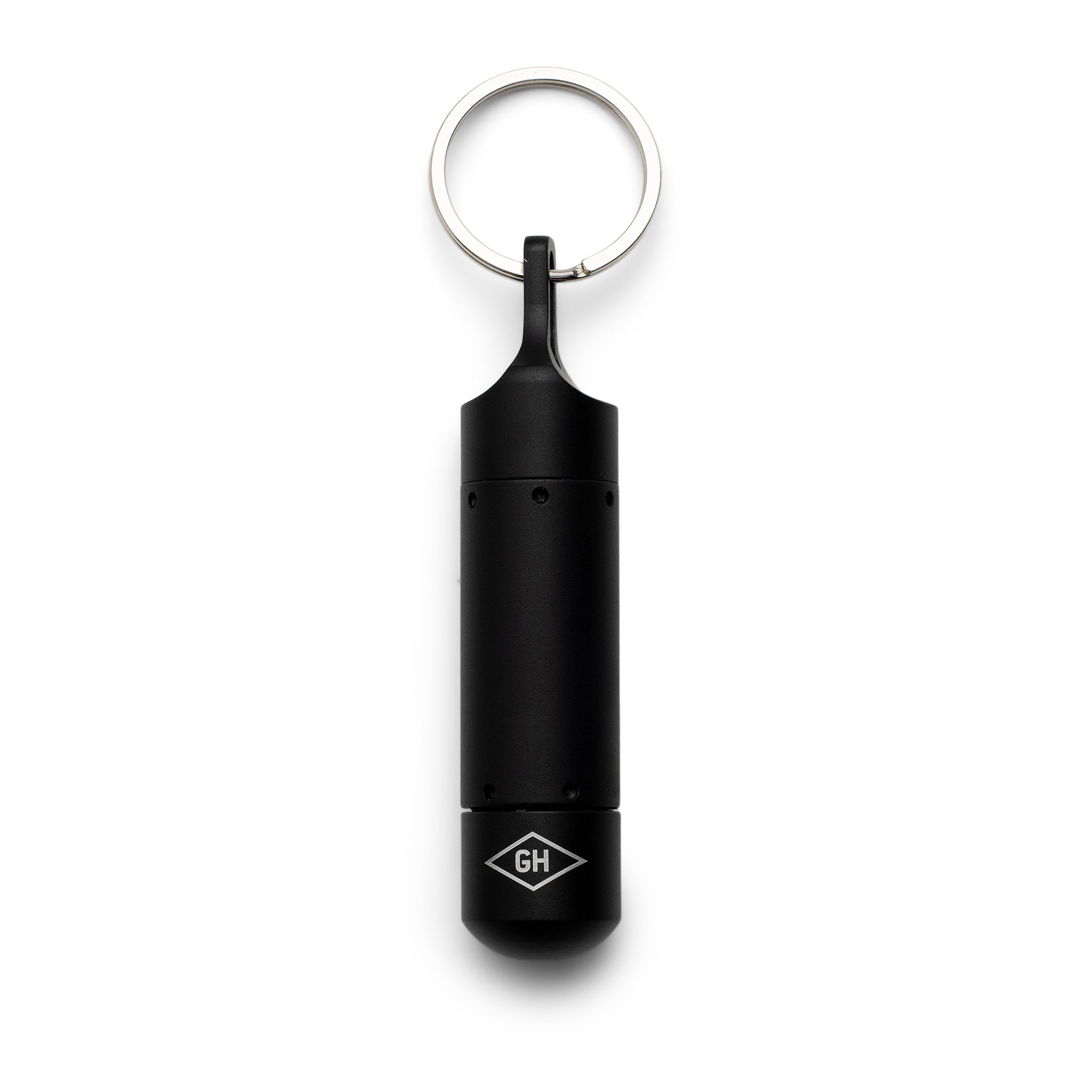 Capsule noire fermée du porte-clés Tech Capsule avec anneau et logo GH sur le fond