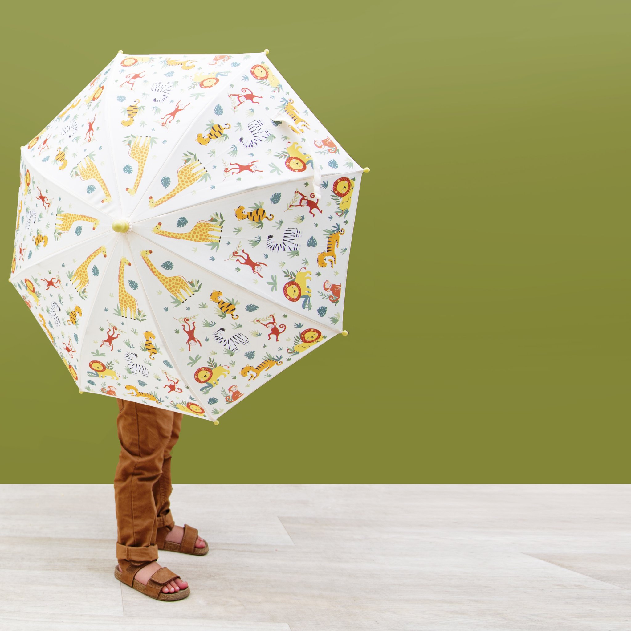 Enfant sous le parapluie enfant Savannah Safari devant un mur vert