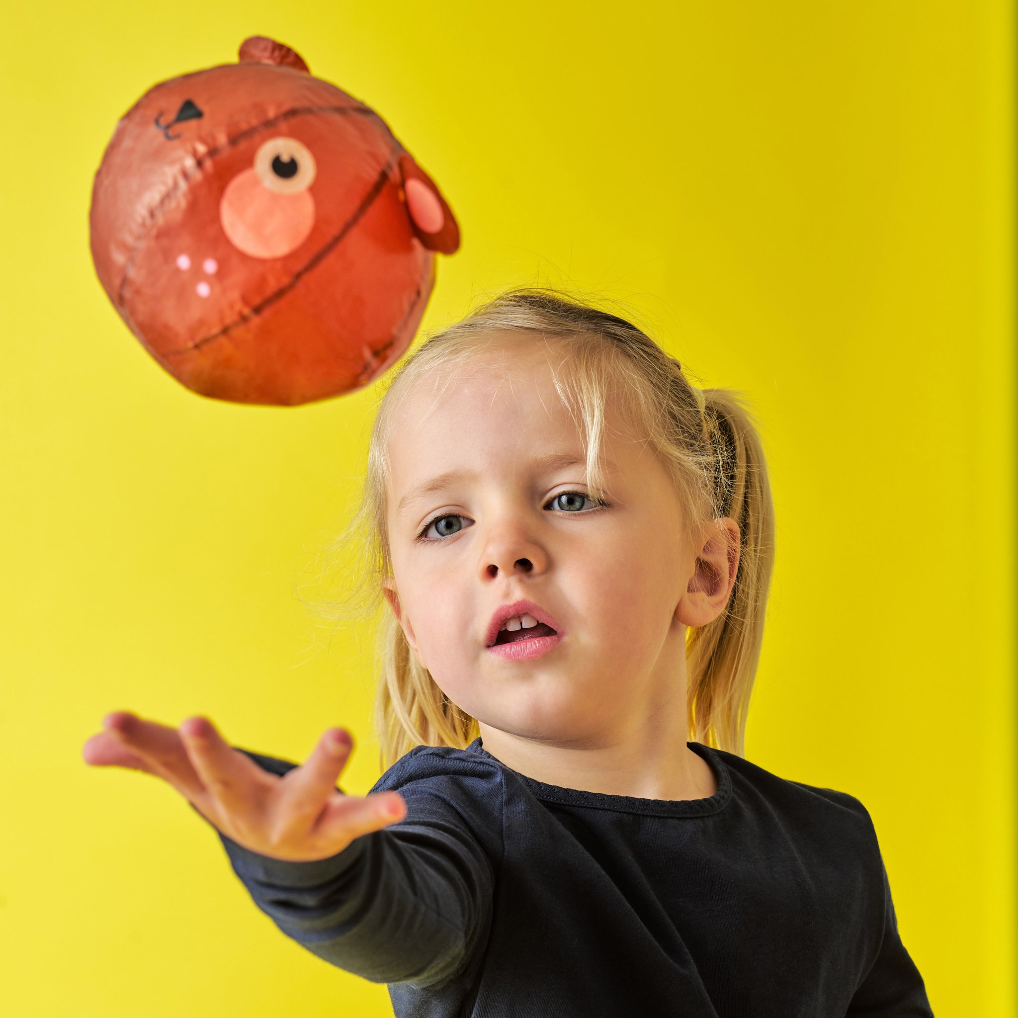 Girl tossing the fox paper balloon in the air