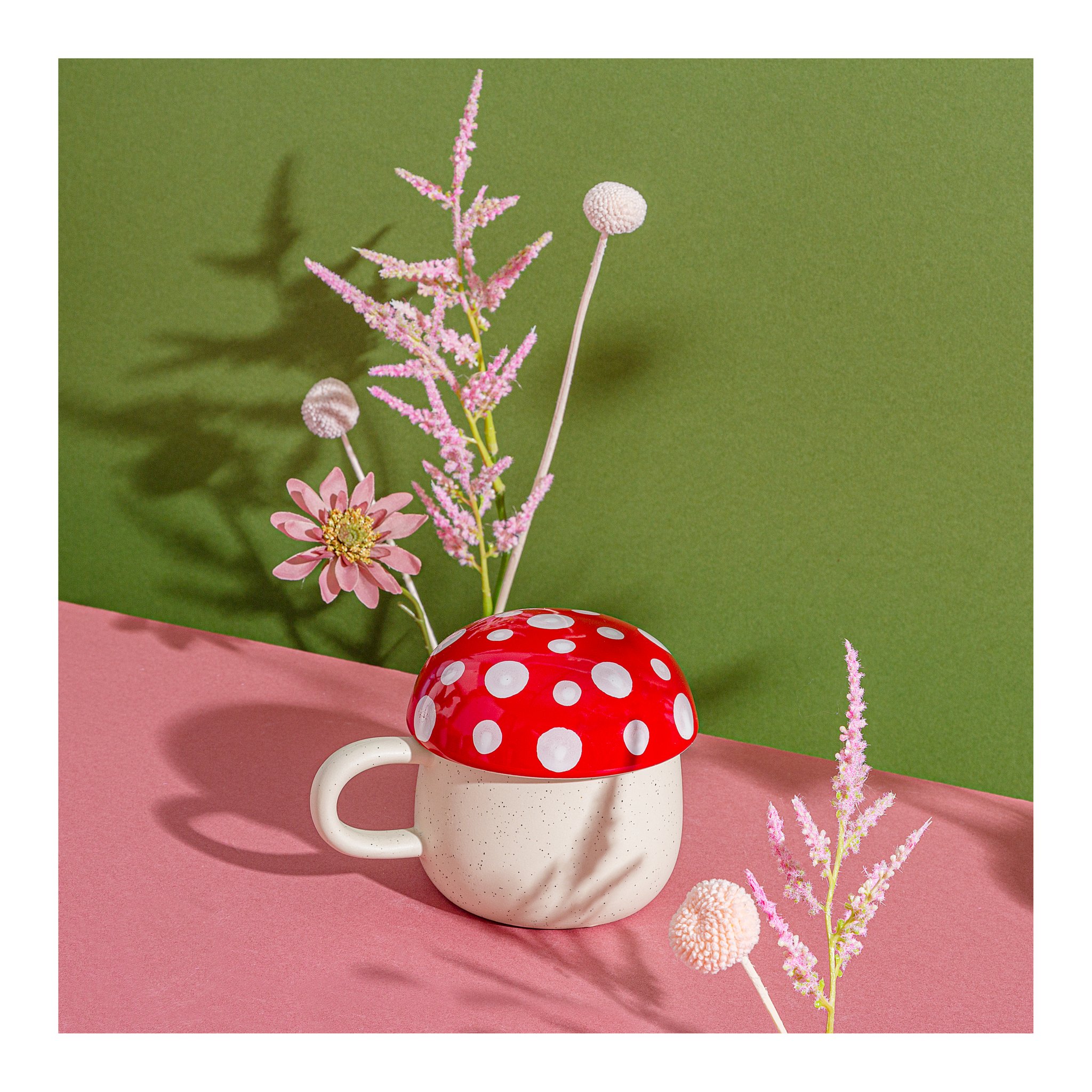 Tazza fungo con fiori su sfondo verde e rosa