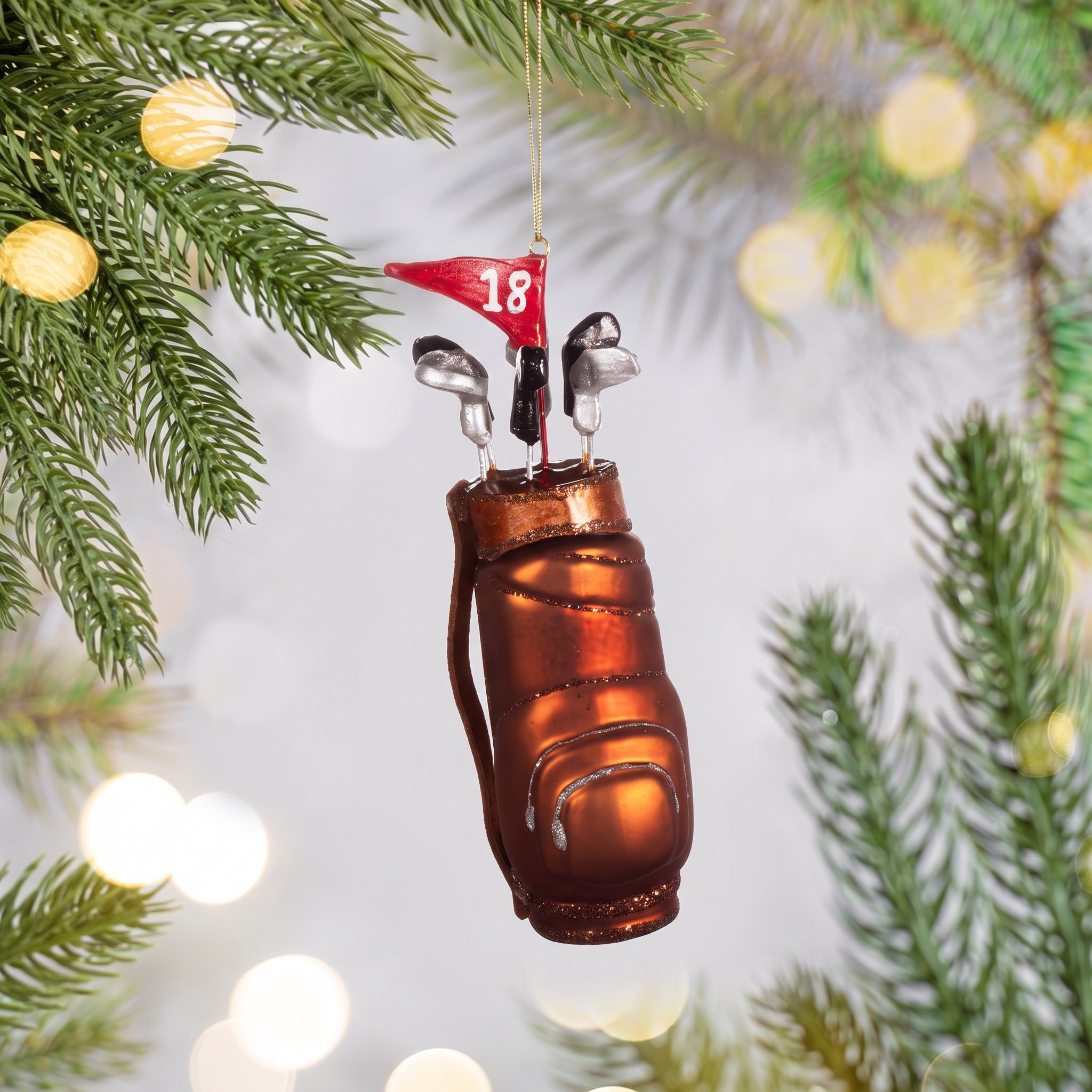 Décoration à Sapin Club de Golf de Sass & Belle sur une branche de sapin avec des lumières scintillantes