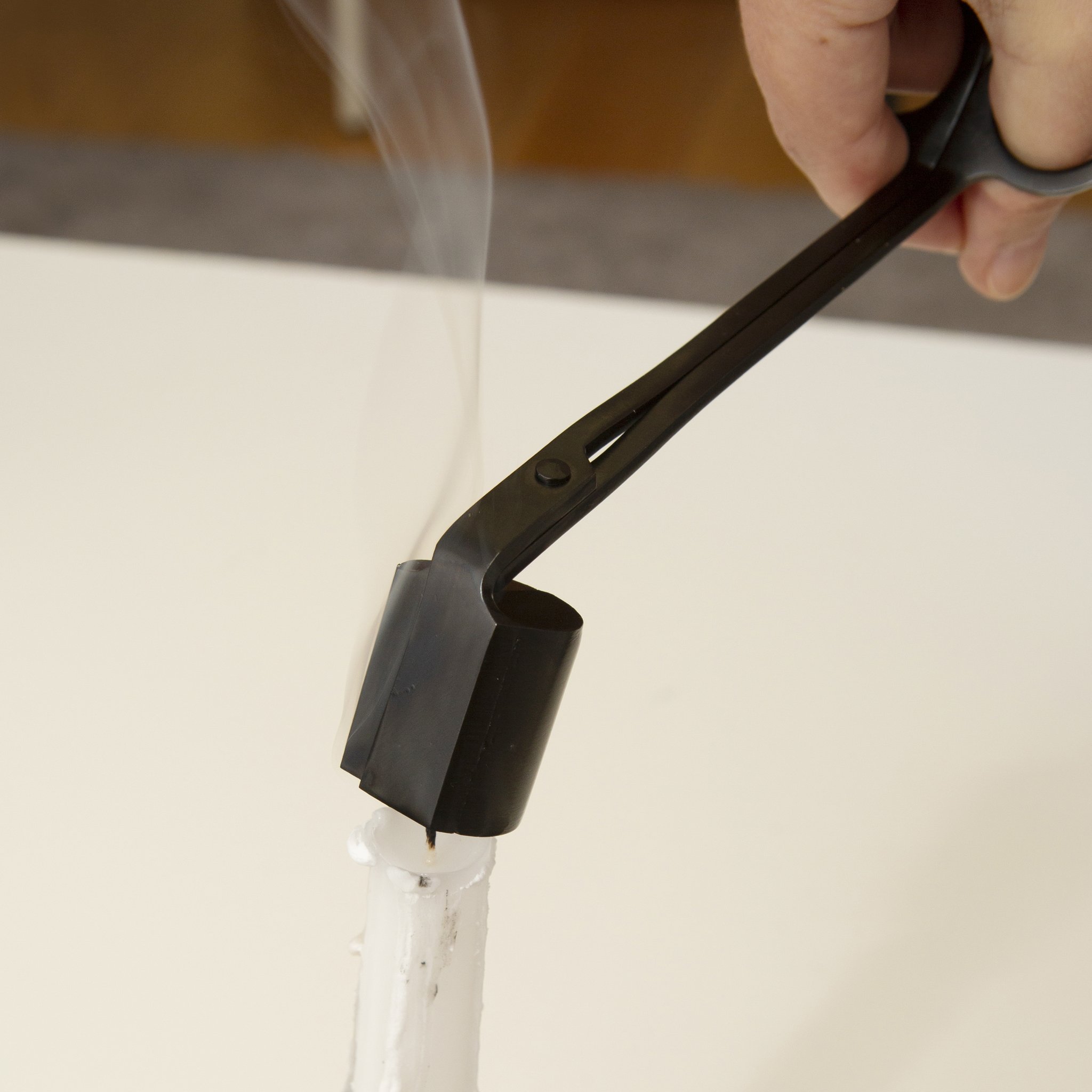 Outil à bougie avec éteignoir sur une bougie fumante