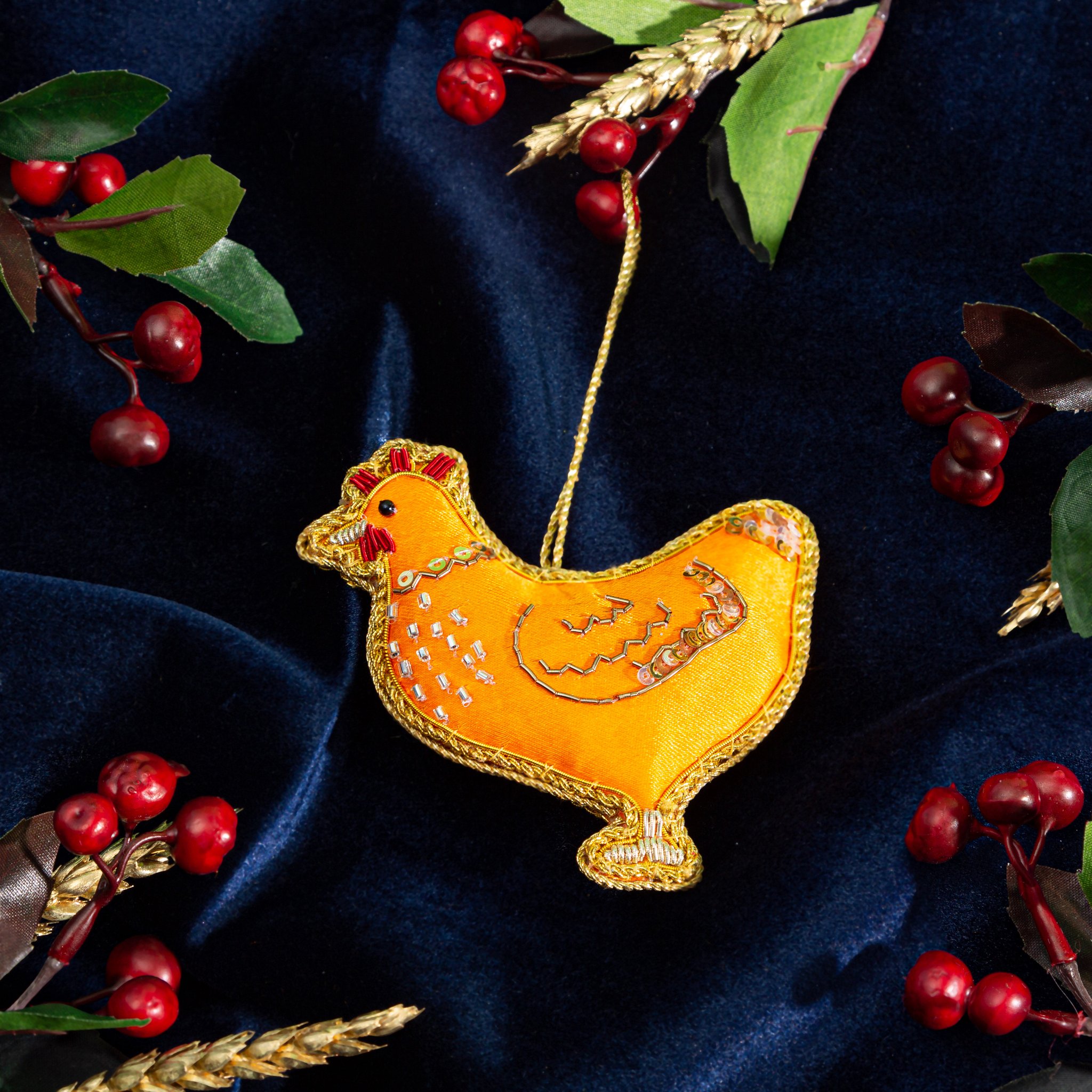 Weihnachtsschmuck Zari-Huhn auf blauem Samt mit roten Beeren