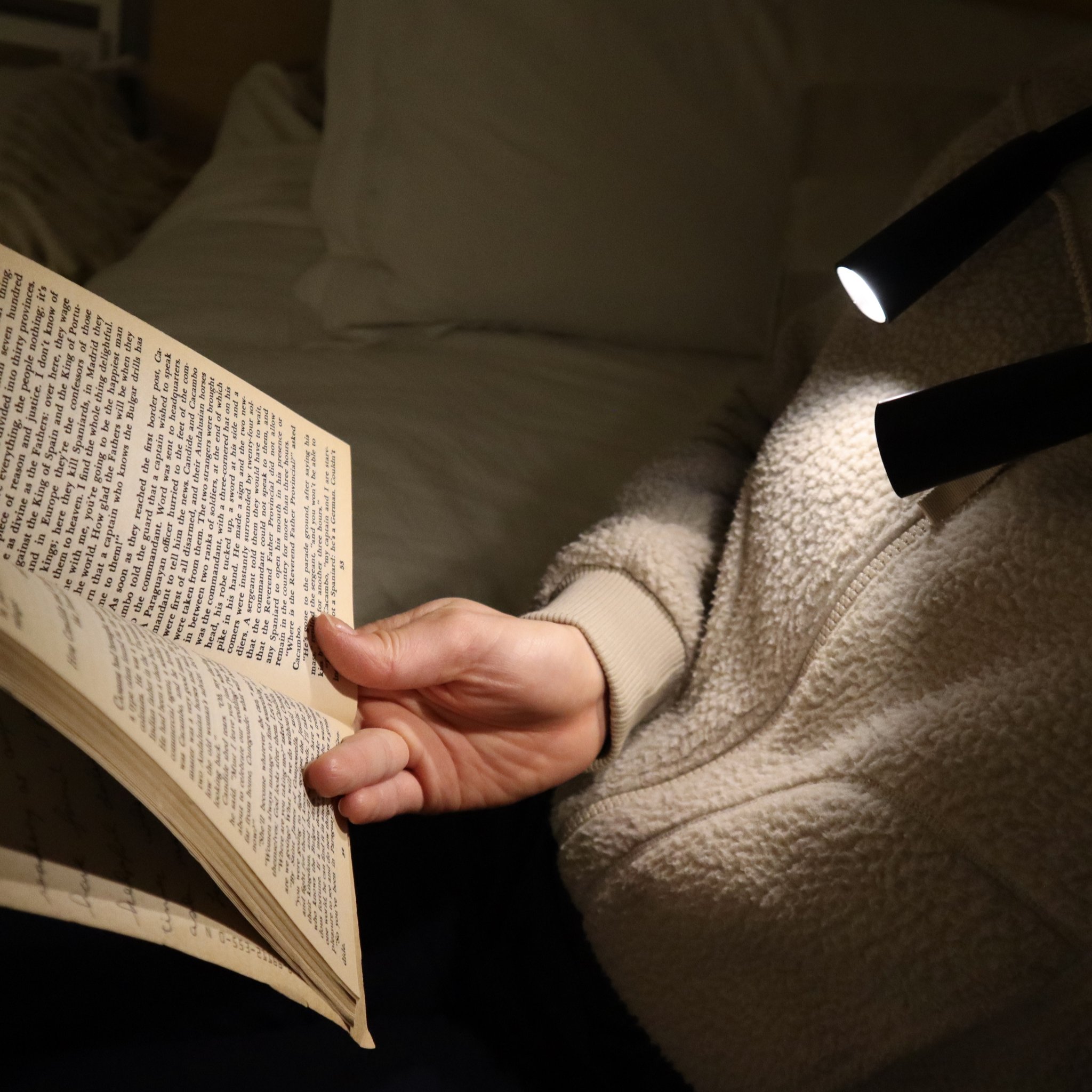 Leseleuchte für den Hals beim Lesen eines Buchs im Bett