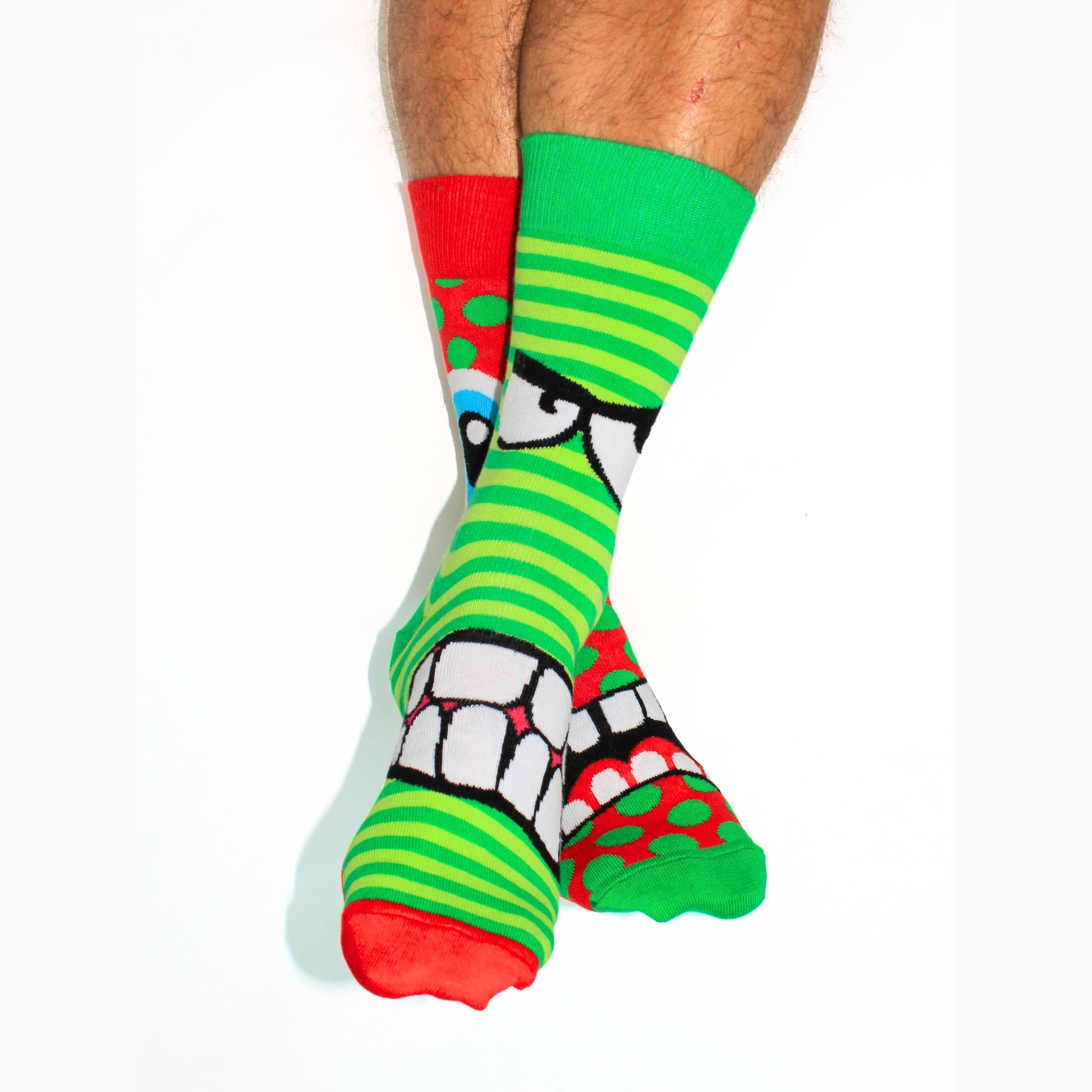 Deux chaussettes dépareillées avec dents et yeux portées aux pieds