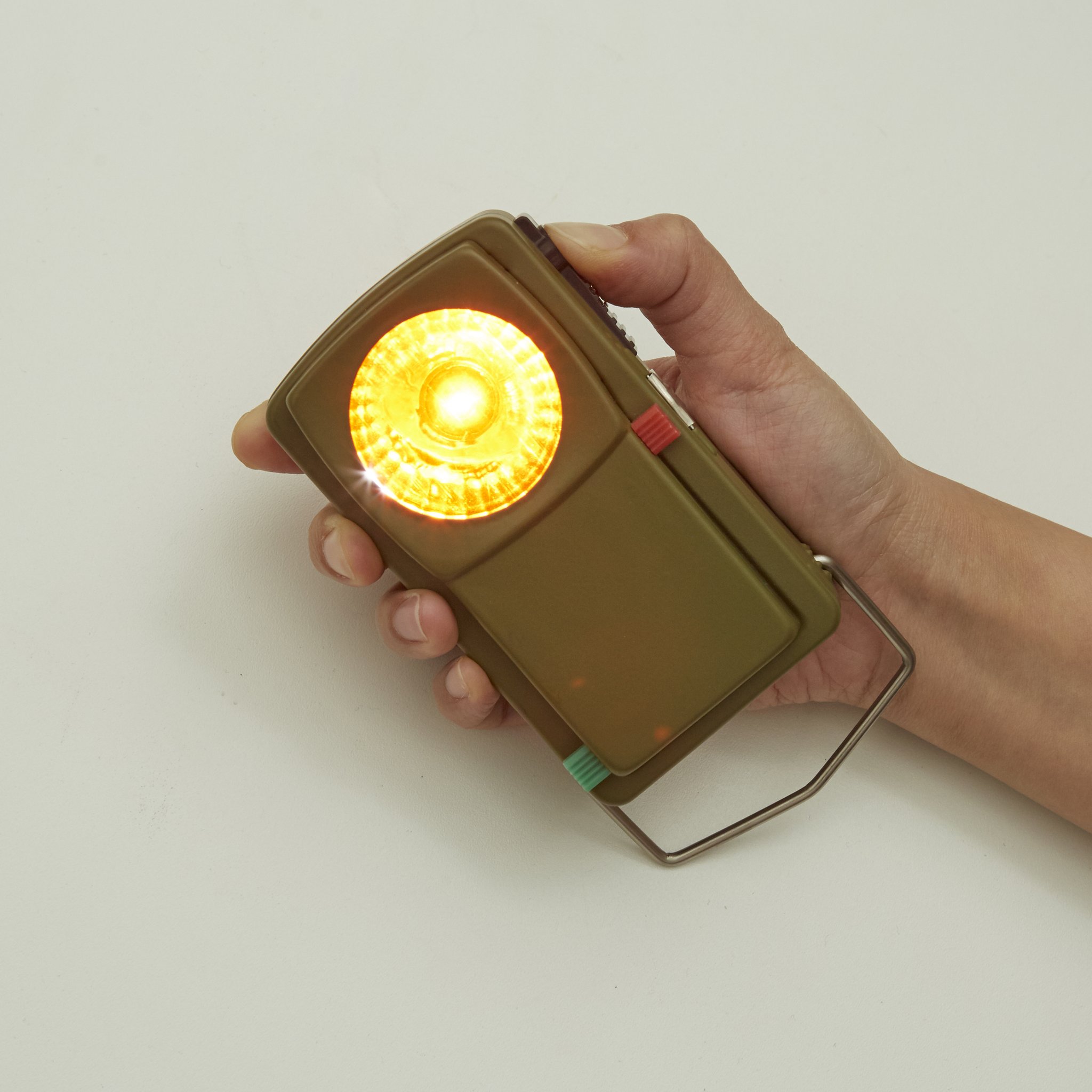 Hand hält die Morse-Code-Taschenlampe mit gelb leuchtender Linse