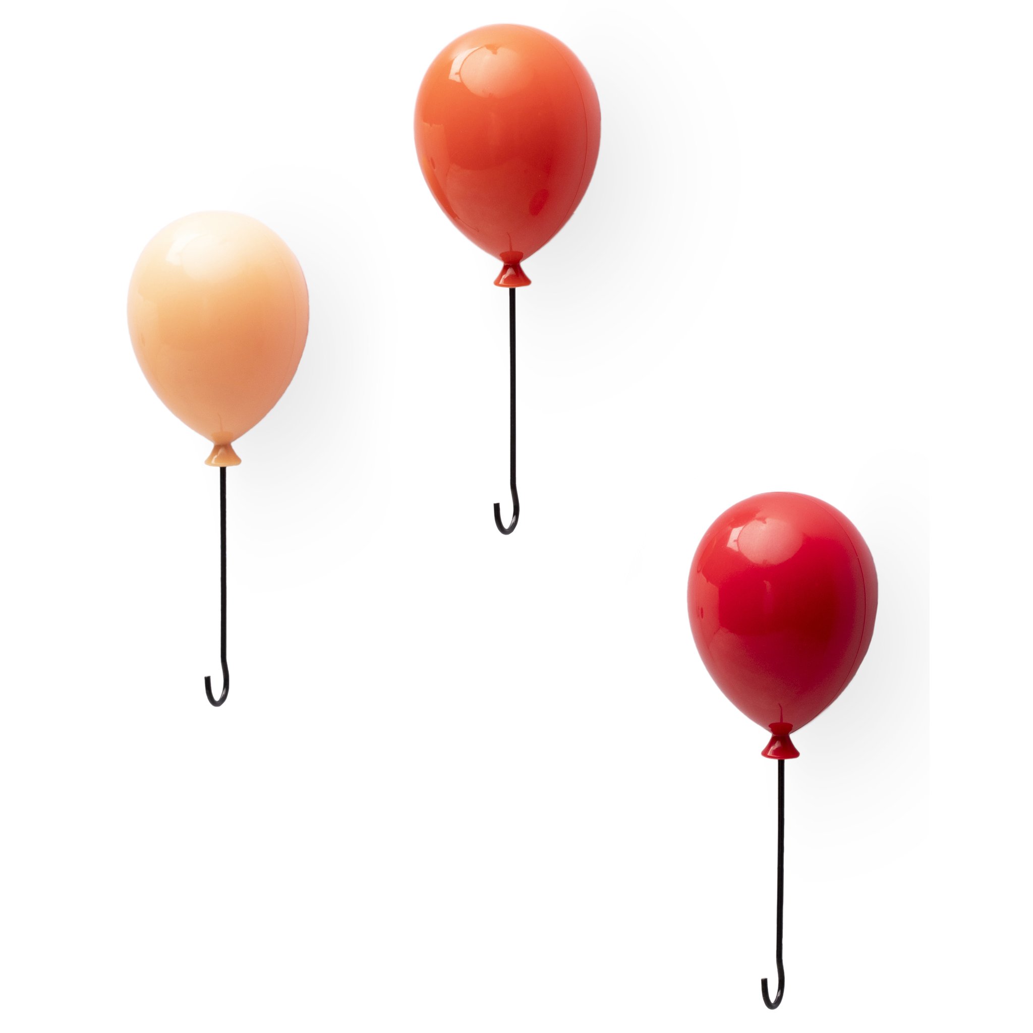 Drei Schlüsselhänger in Luftballonform an einer weissen Wand