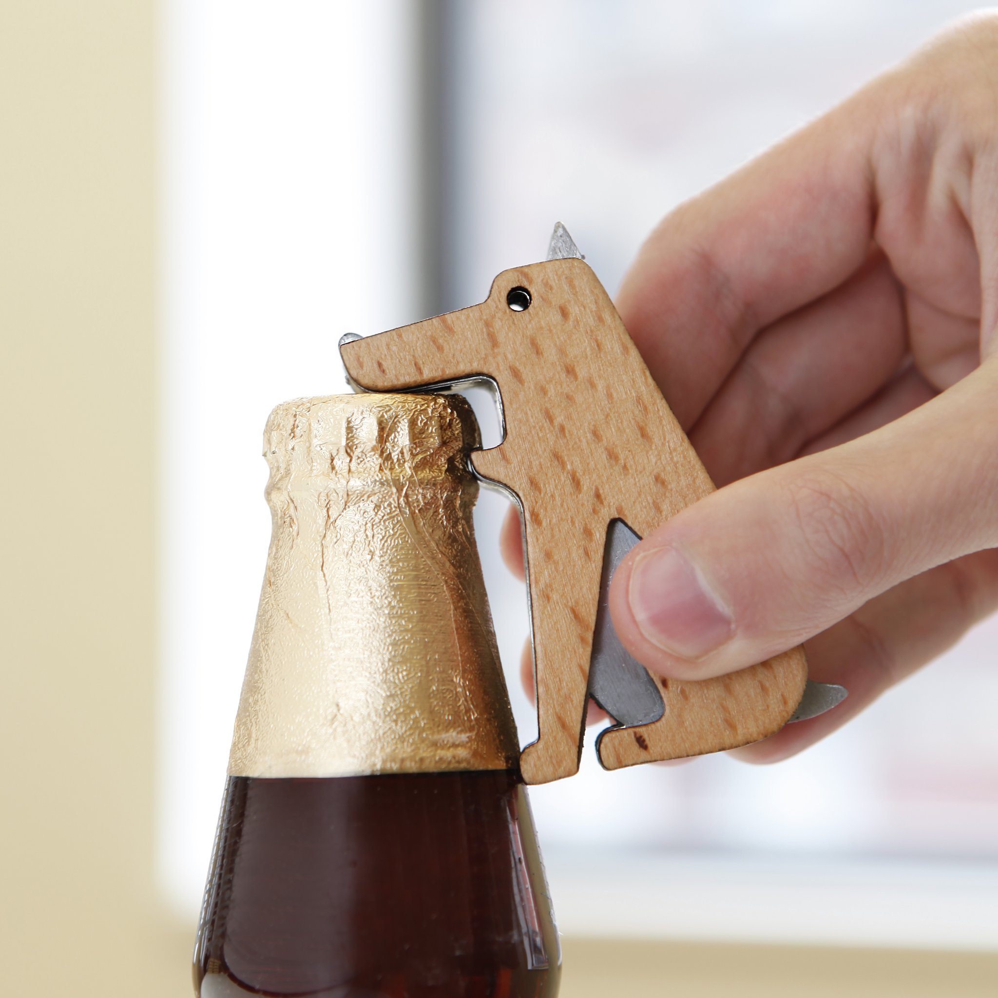 Hand öffnet eine Flasche mit dem Fang!-Hundeöffner