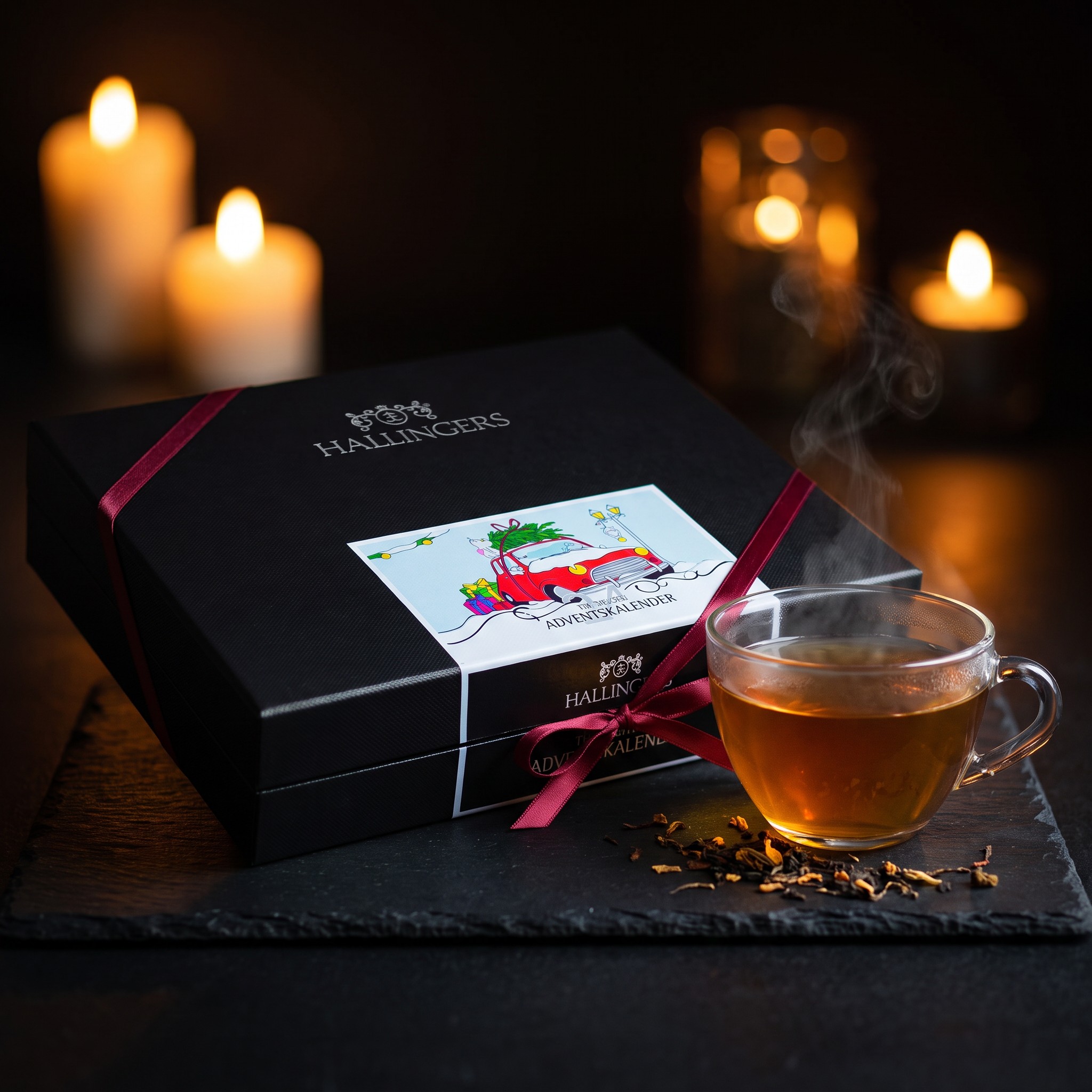 Geschlossene Geschenkbox des Tee-Adventskalenders mit Christmas-Car-Etikett, Schleife und einer Tasse Tee