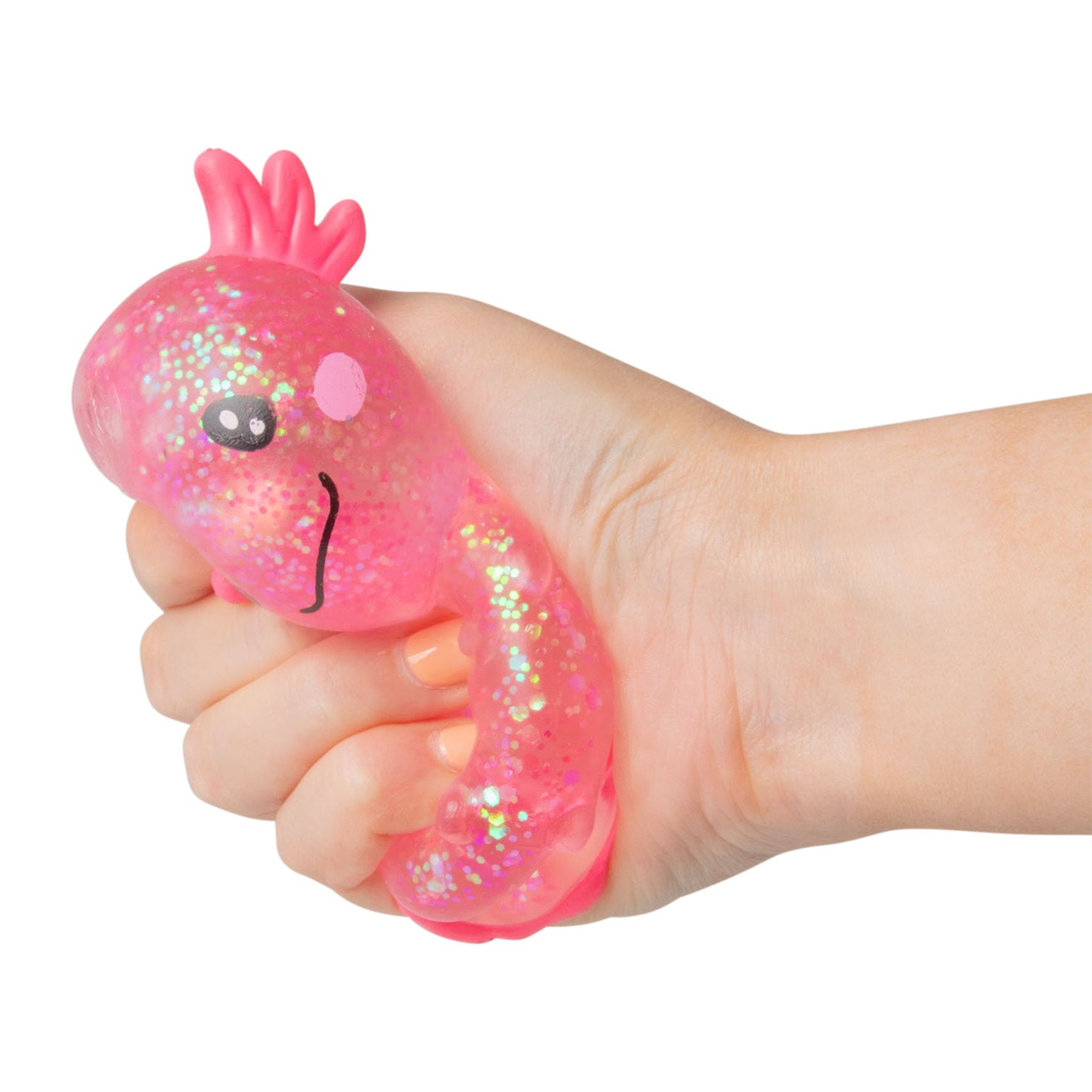 Hand quetscht einen pinken Axolotl-Squishy mit Glitzerfüllung