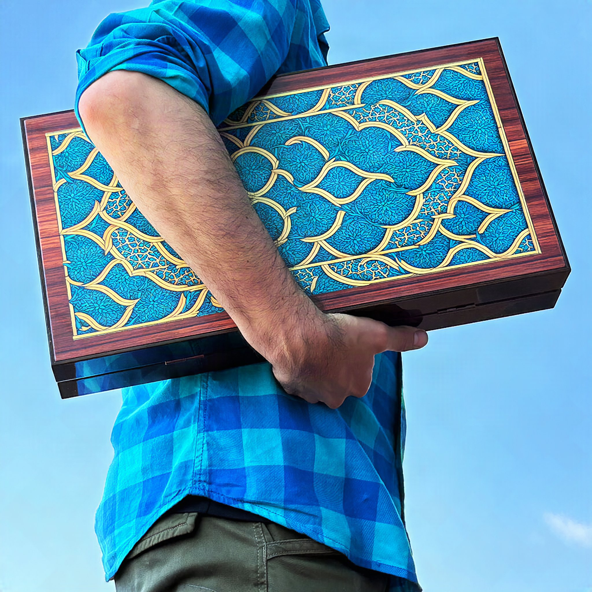 Mann trägt das geschlossene Backgammon-Set Oriental unter dem Arm