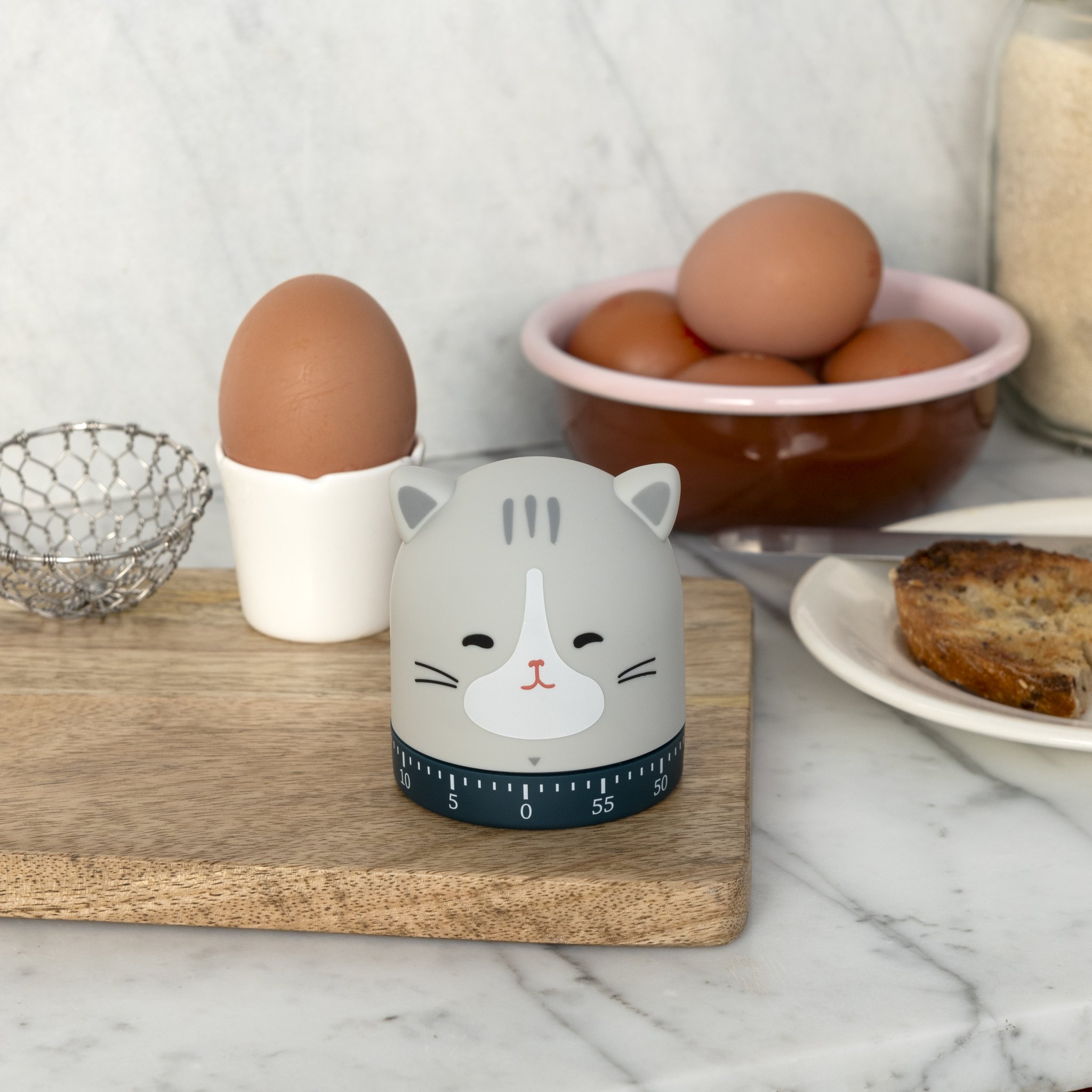 Küchenuhr Katze in der Küche mit Eierschale und Frühstück im Hintergrund