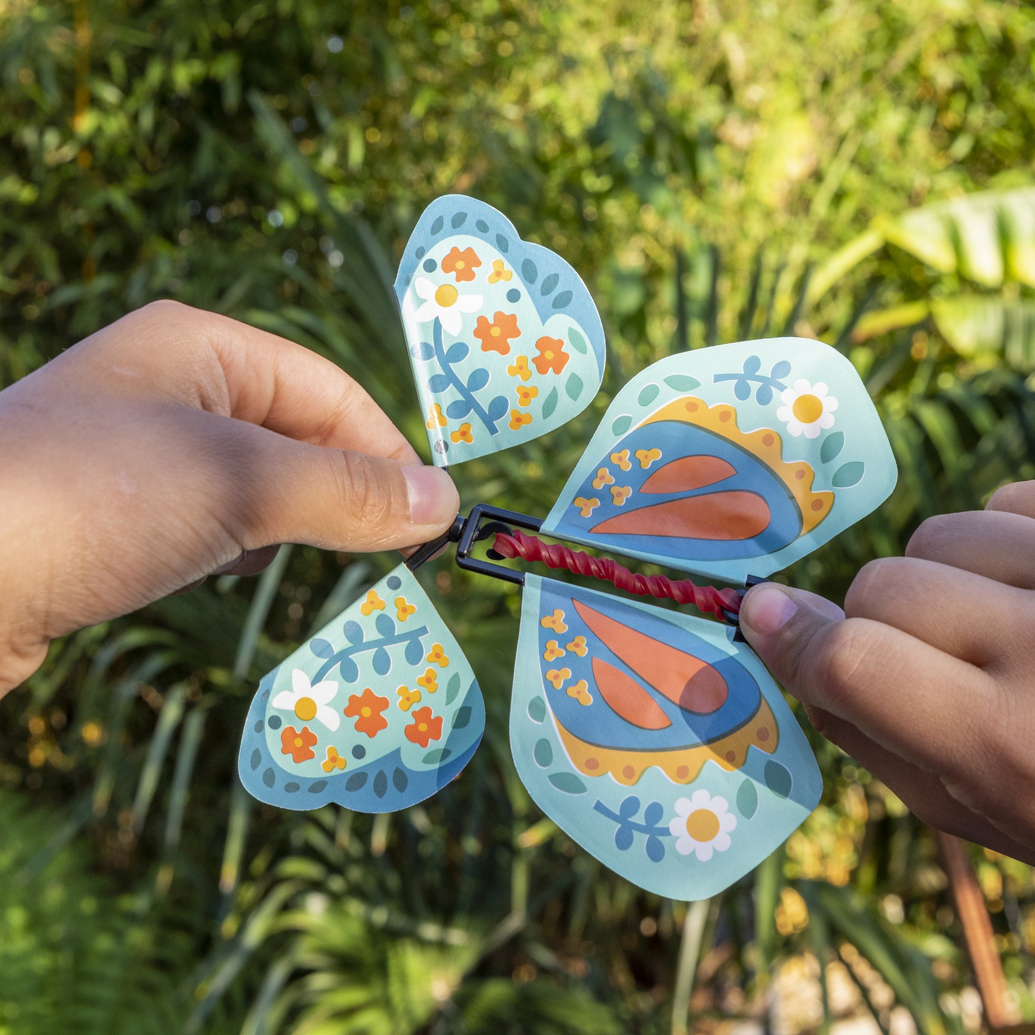 Main remontant le papillon magique dans le jardin