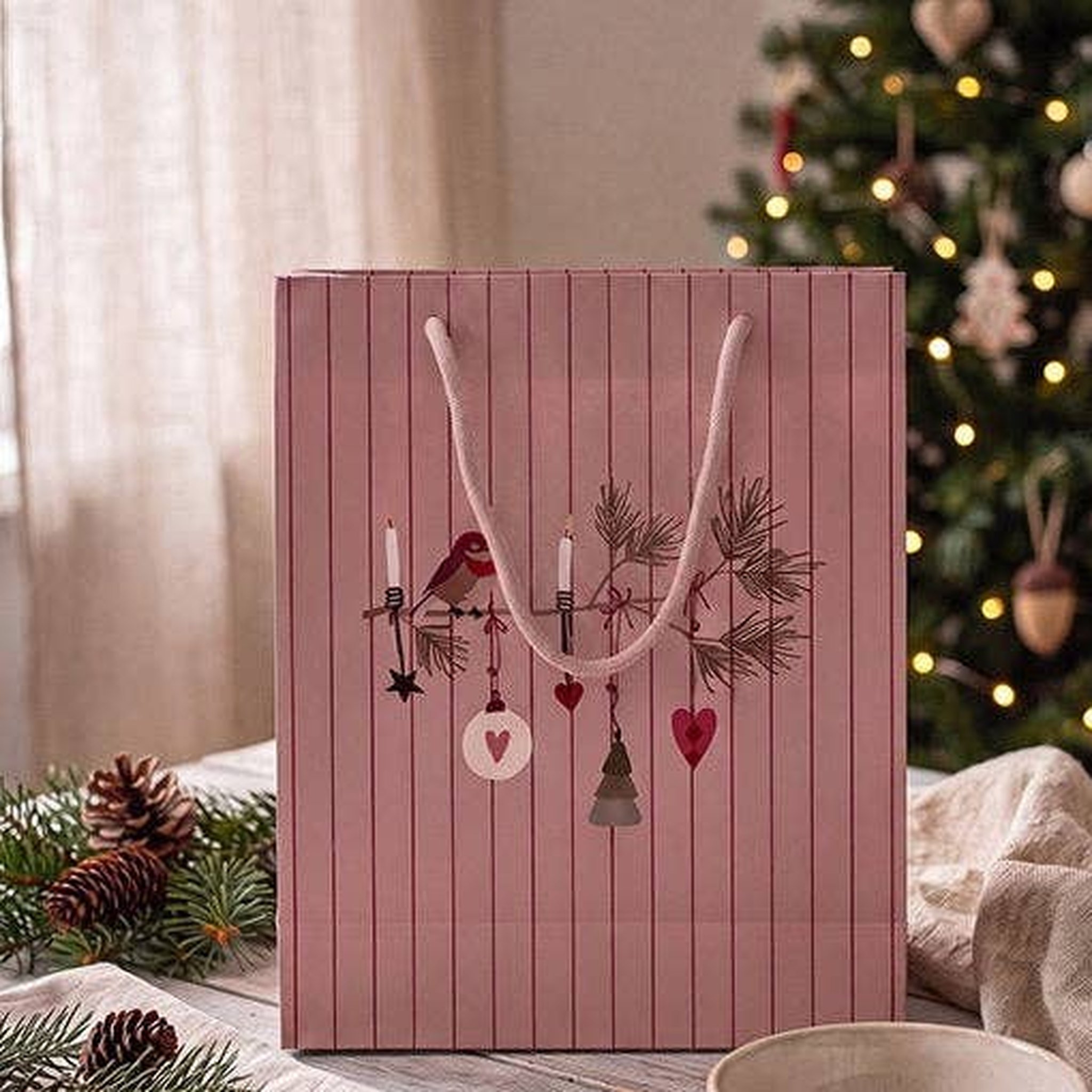 Sacchetto regalo rosa con uccellino e decori natalizi – foto d'atmosfera