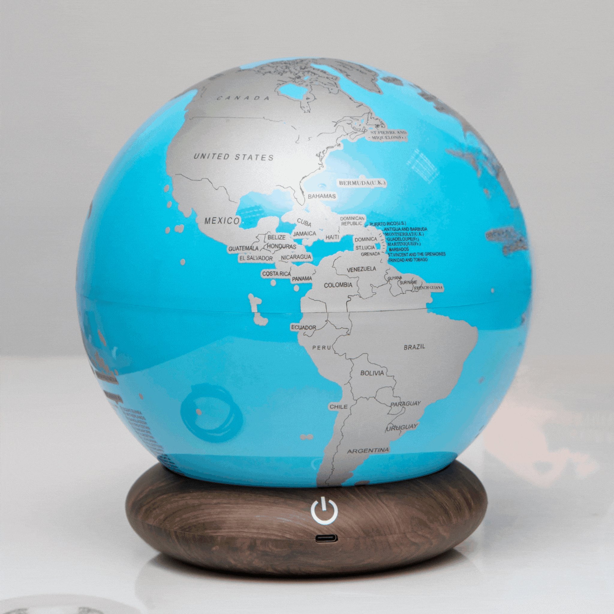 Mappamondo da grattare Globe Trotter spento su un tavolo chiaro, le Americhe ancora sotto lo strato argentato