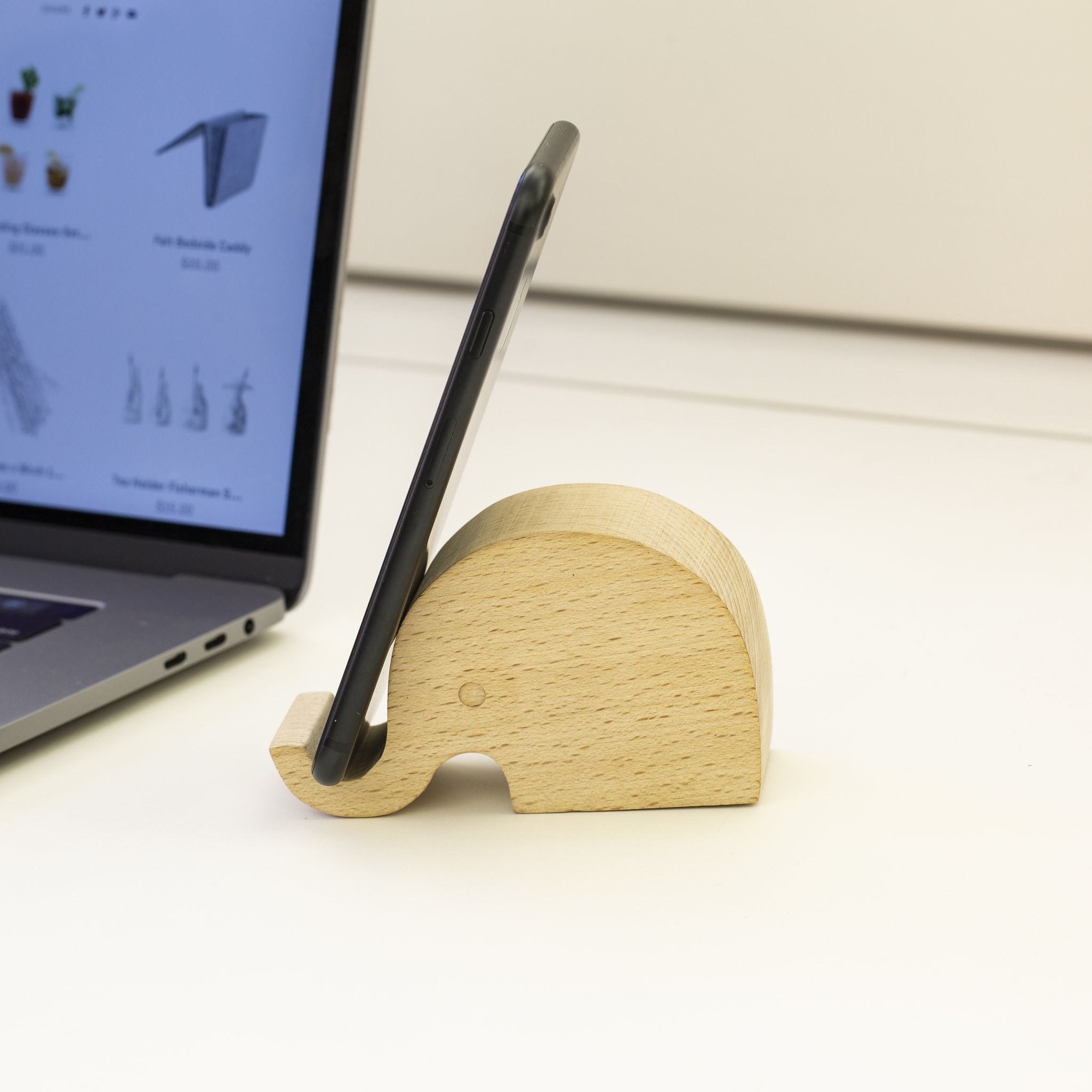 Elefanten-Handyhalter mit Smartphone neben einem Laptop