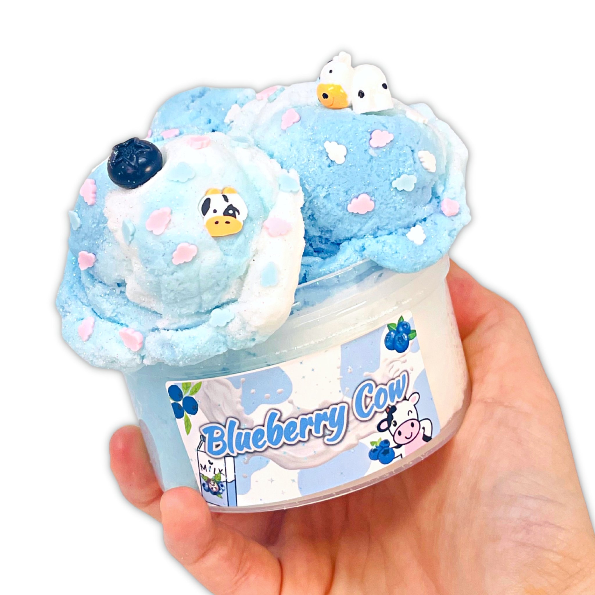 Hand hält den blau-weissen Blueberry Cow Cloud-Slime