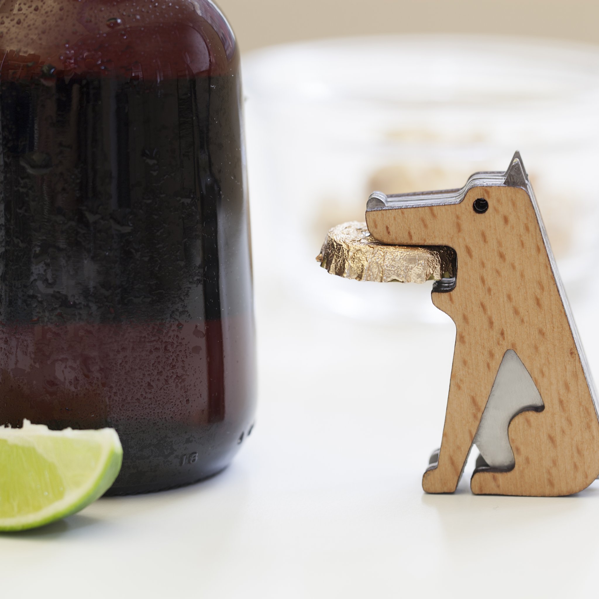 Ouvre-bouteille chien Fetch près d'une bouteille, d'un citron vert et d'un verre