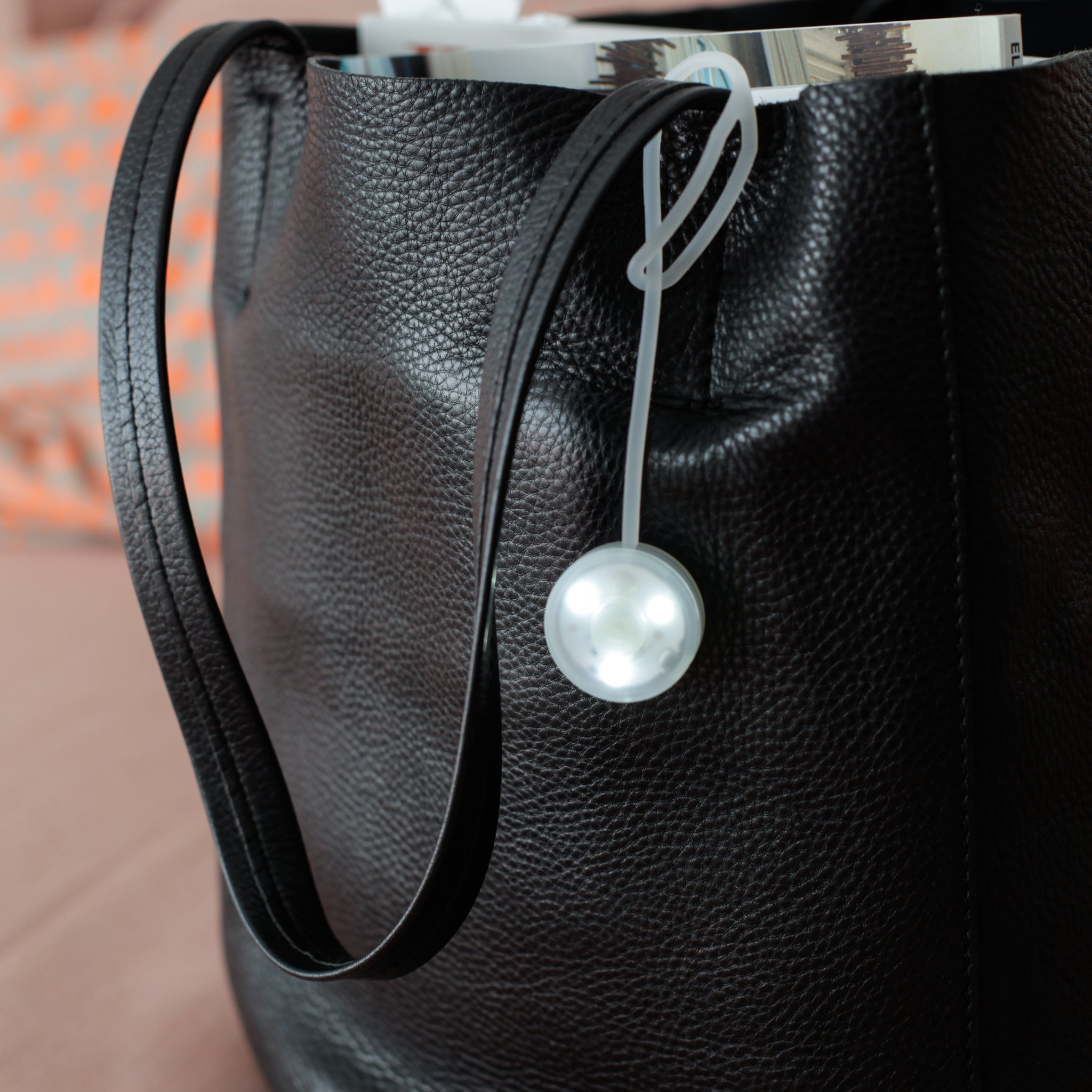 Handtaschen-Lampe am Henkel einer Ledertasche befestigt